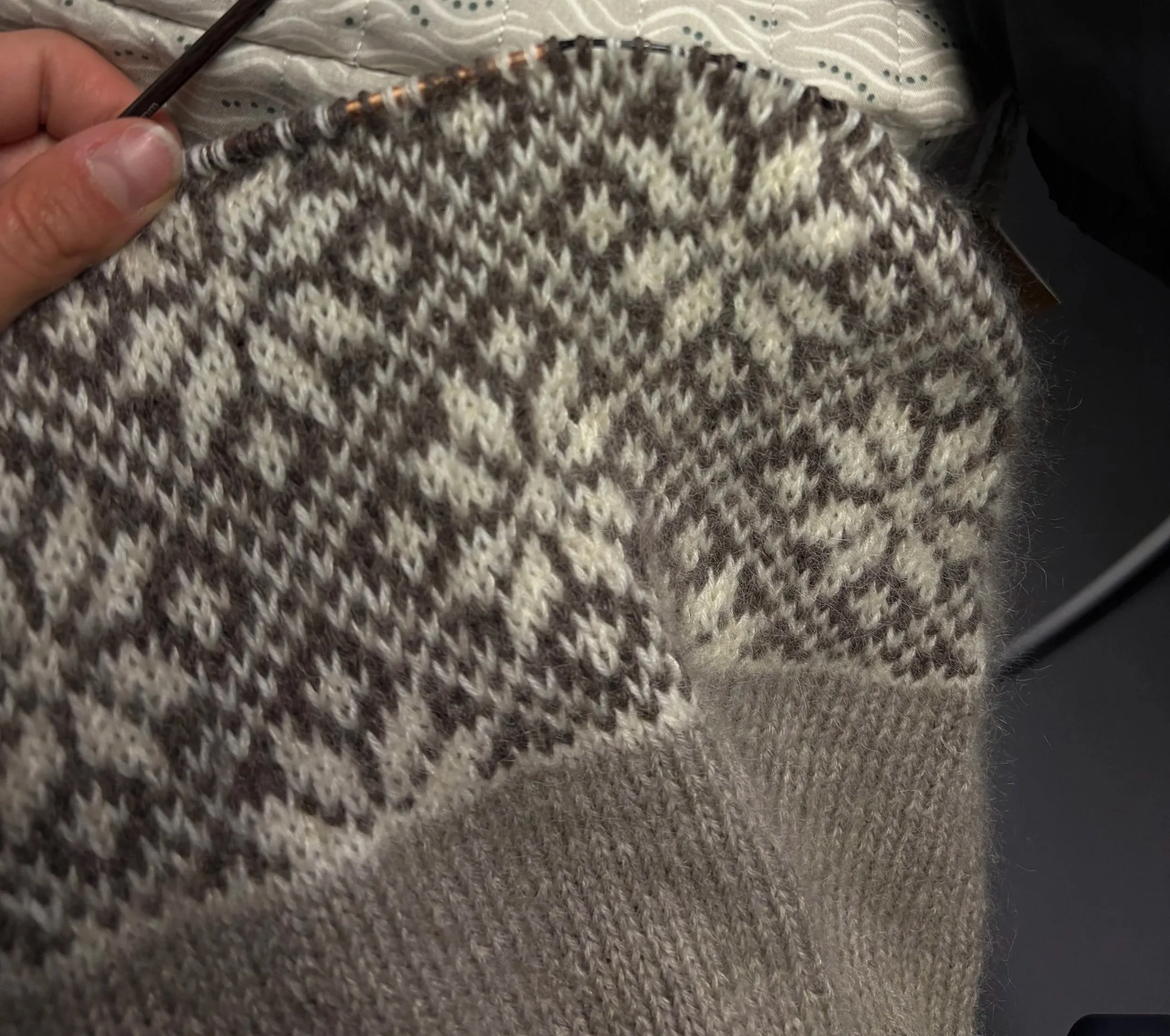 Nahaufnahme eines Fair-Isle-Pullover in Grau und Weiß mit Sternenmuster nach traditioneller norwegischer Art 