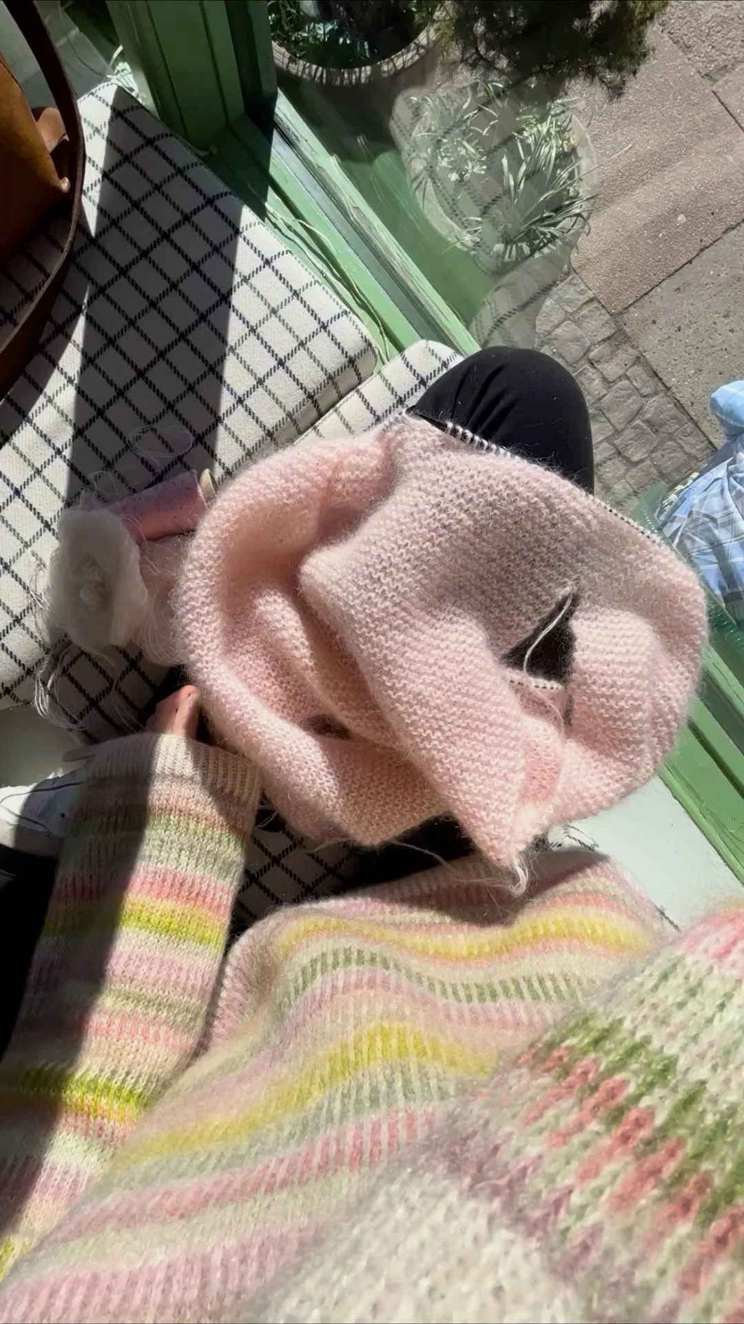 Bunter Fair-Isle-Pullover in Grün- und Rosatönen gestrickt aus Mohair getragen von einer Frau mit rosanem Mohair Strickpullover auf den Beinen liegend
