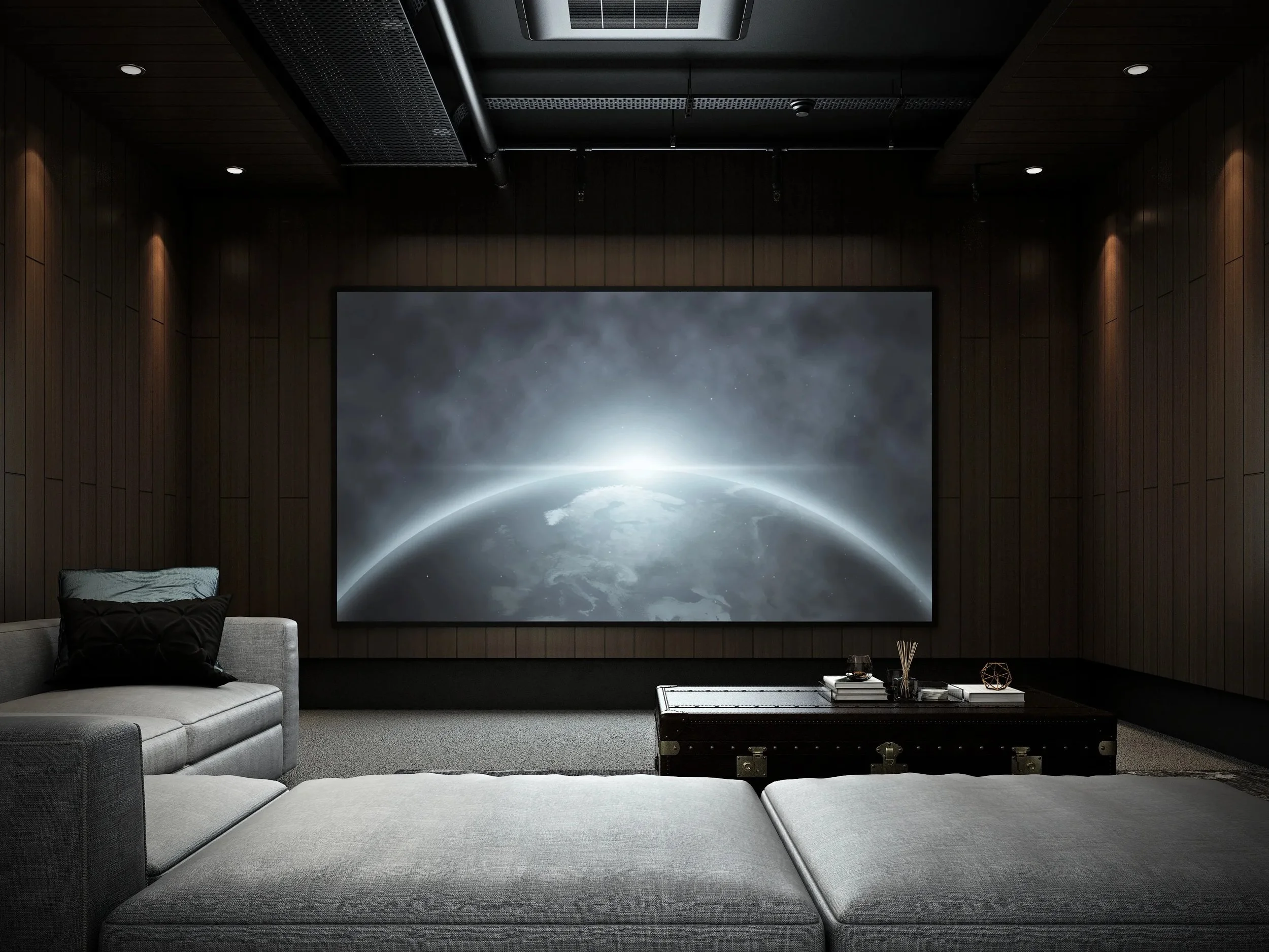Sala de cine en una habitación con paredes de madera oscura, un gran proyector que muestra la Tierra desde el espacio, un sofá gris claro, una mesa de centro negra y decoraciones modernas.