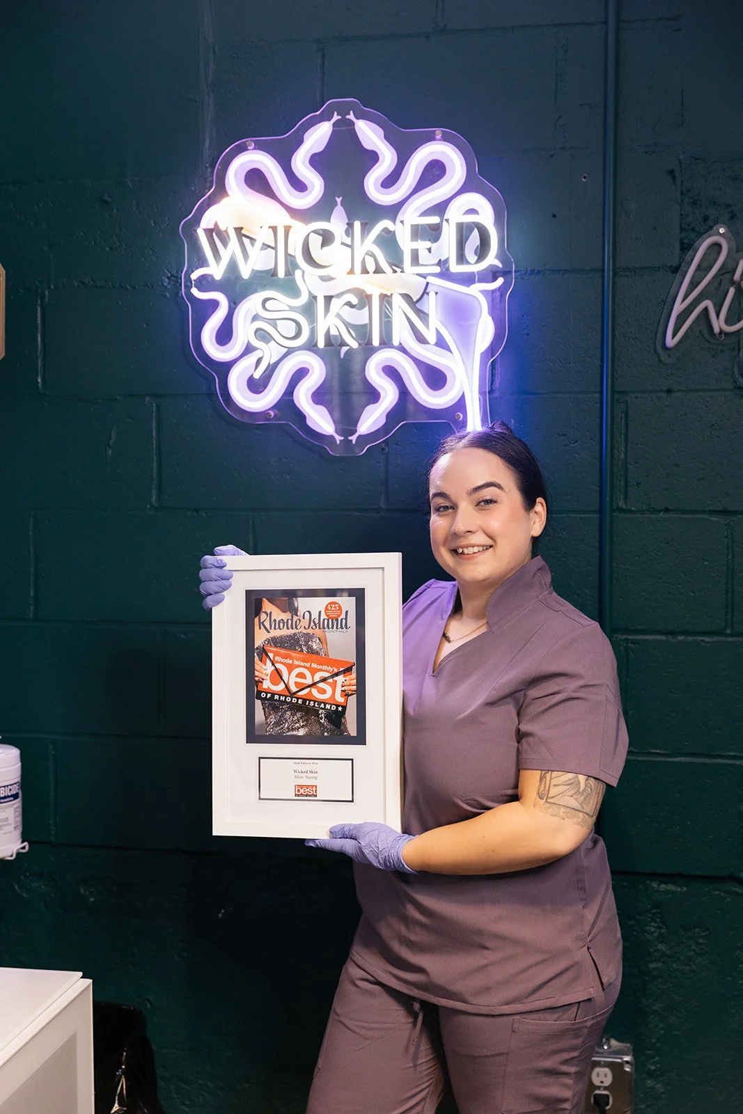 Wicked Skin wax specialist holding a Rhode Island Monthly Best of Rhode Island award