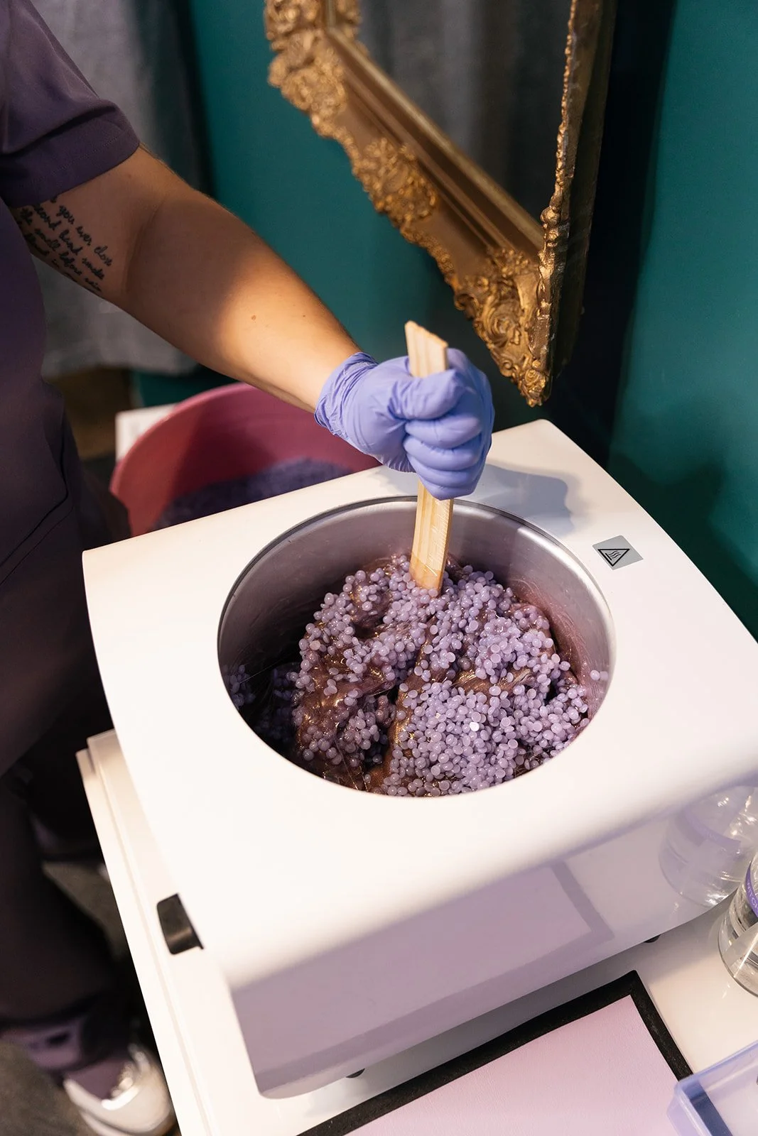 Close-up of hard wax beads being melted and prepared for a waxing service