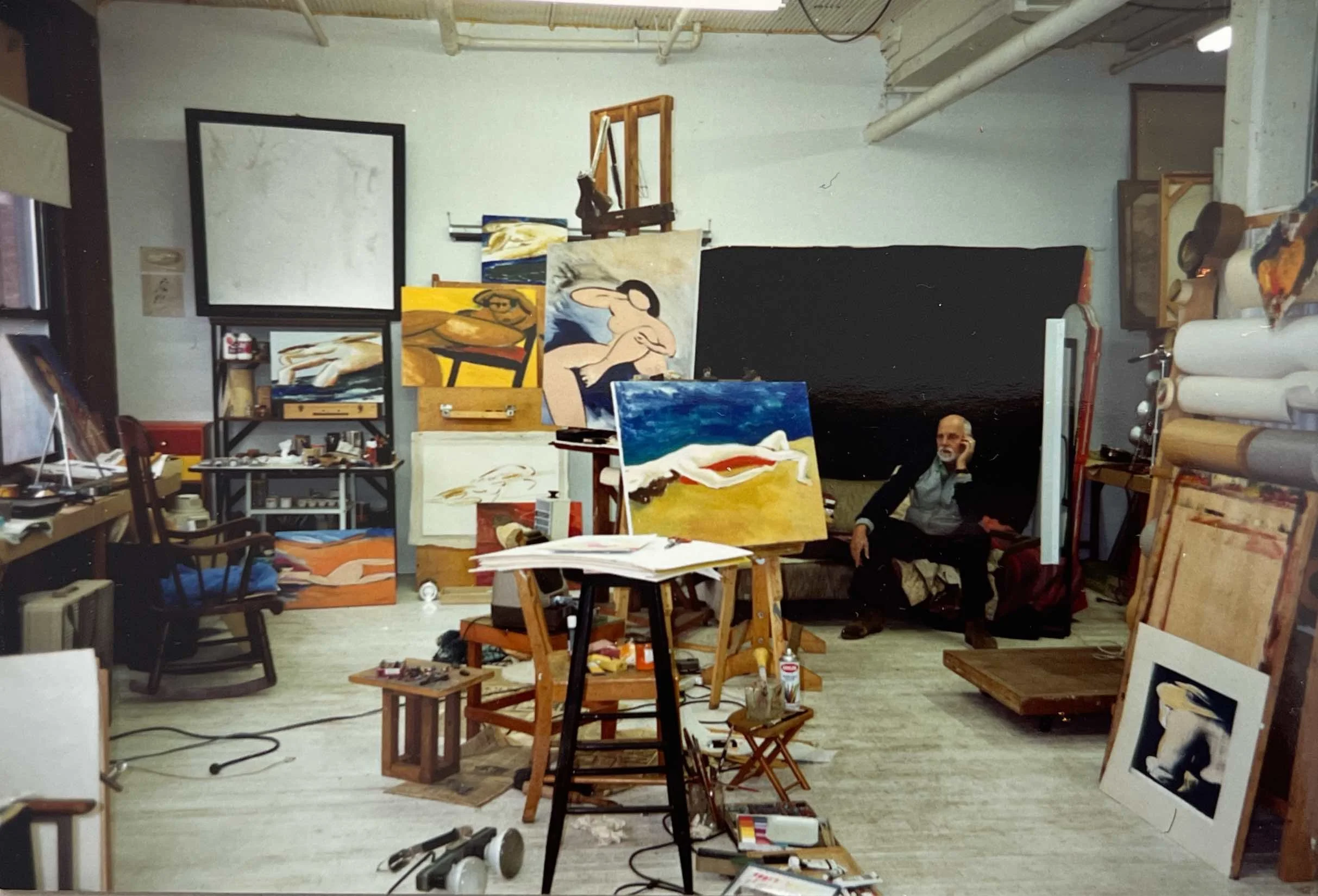 Hans Zandvoort in his Rochester, New York studio, surrounded by paintings, canvases and art materials.