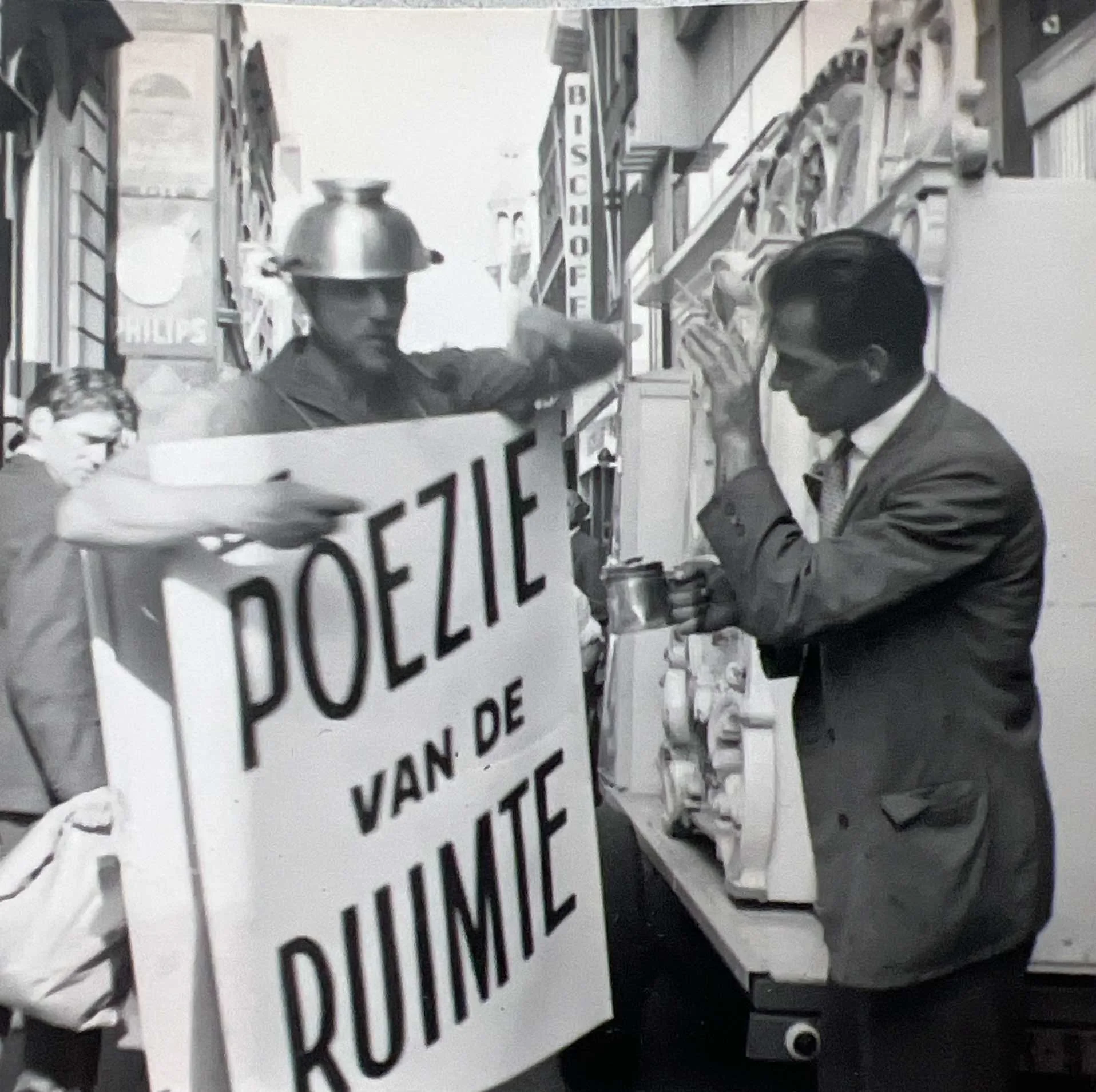 Black-and-white photograph of Hans Zandvoort in Dordrecht wearing sandwich-board advertising panels and a Sputnik-like headpiece made from a colander and projecting forks, 16 September 1961.