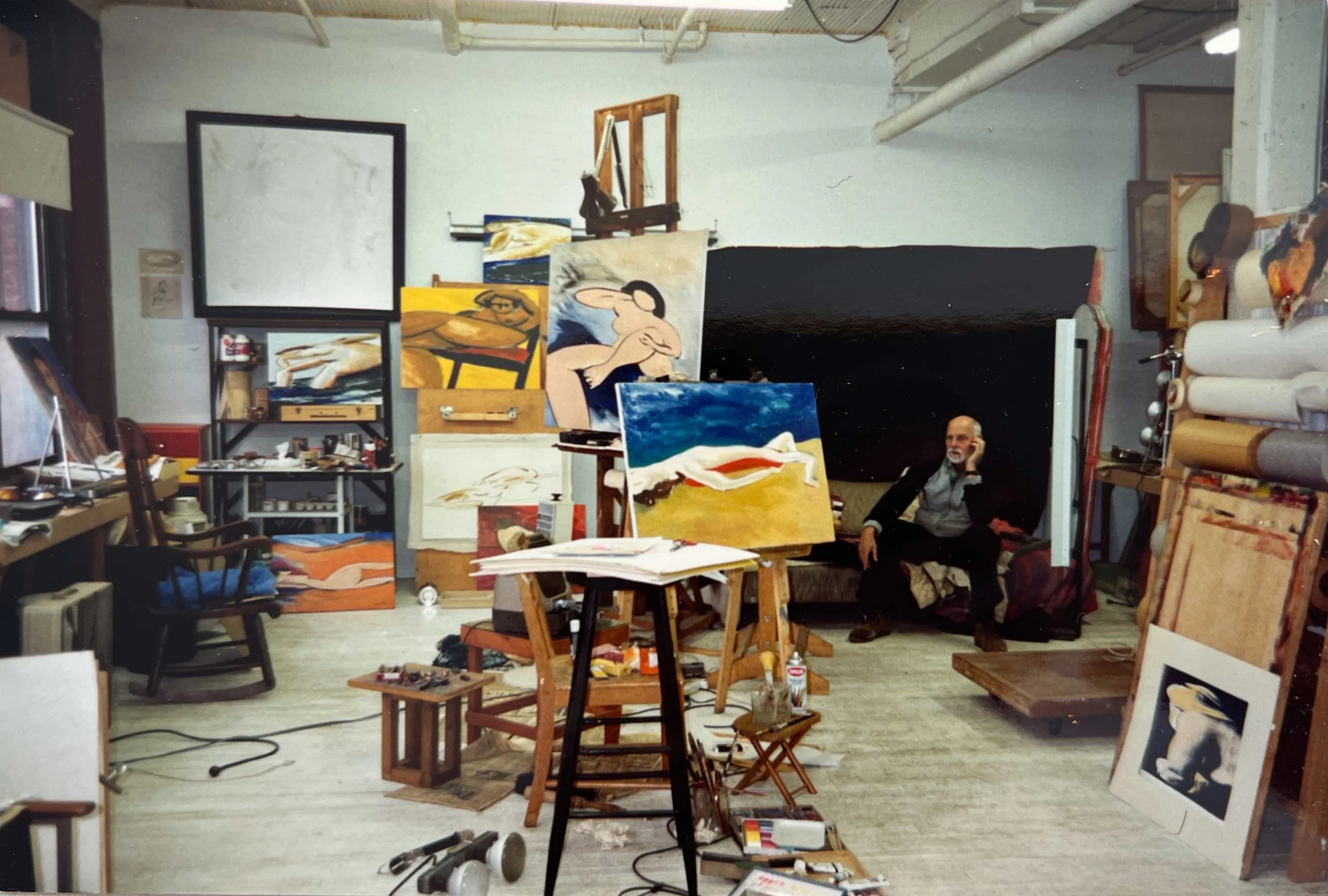 Hans Zandvoort in his Rochester, New York studio, surrounded by paintings, canvases and art materials.