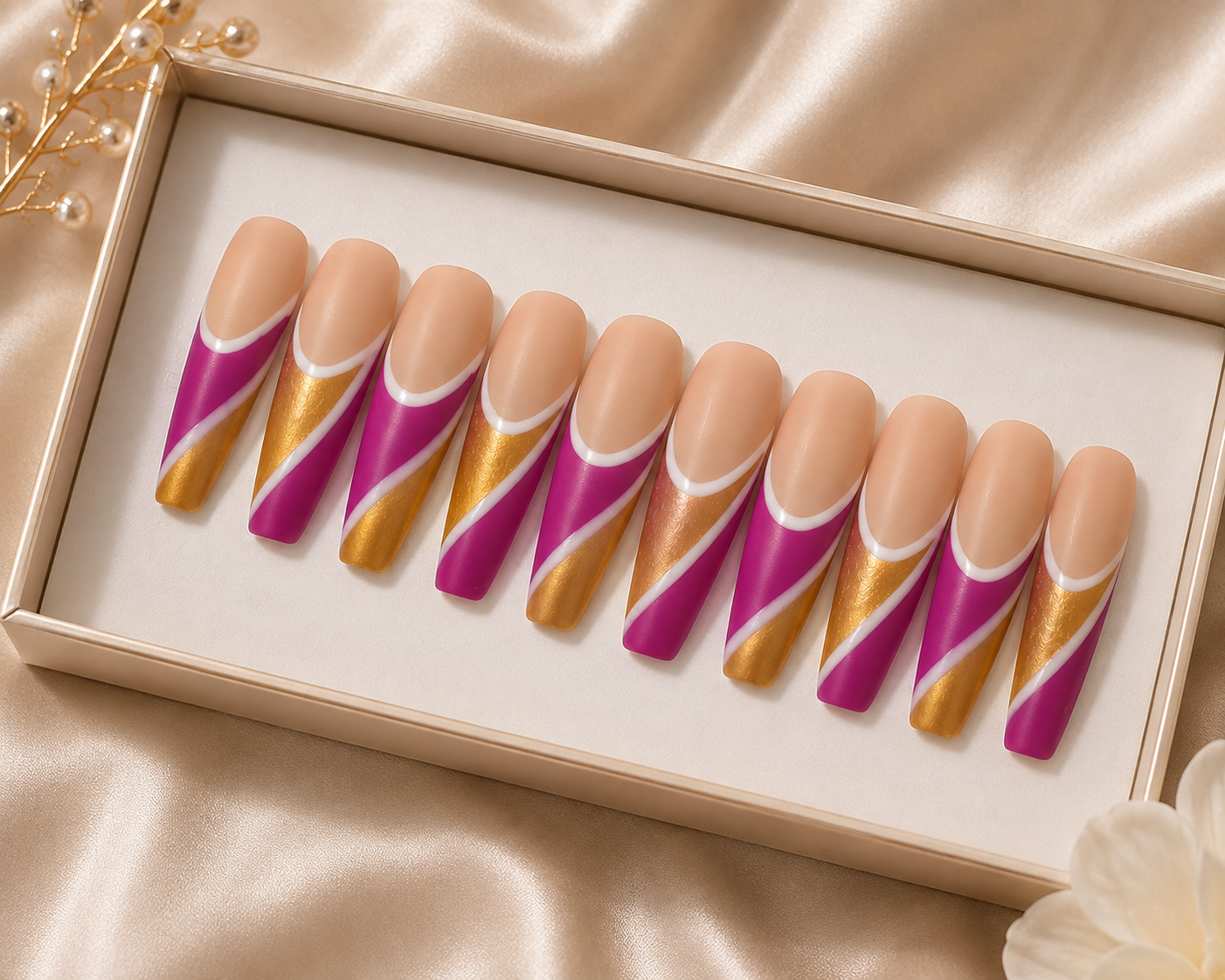 Set of artificial nails with pink, gold, and white swirl design displayed in a cream-colored box.
