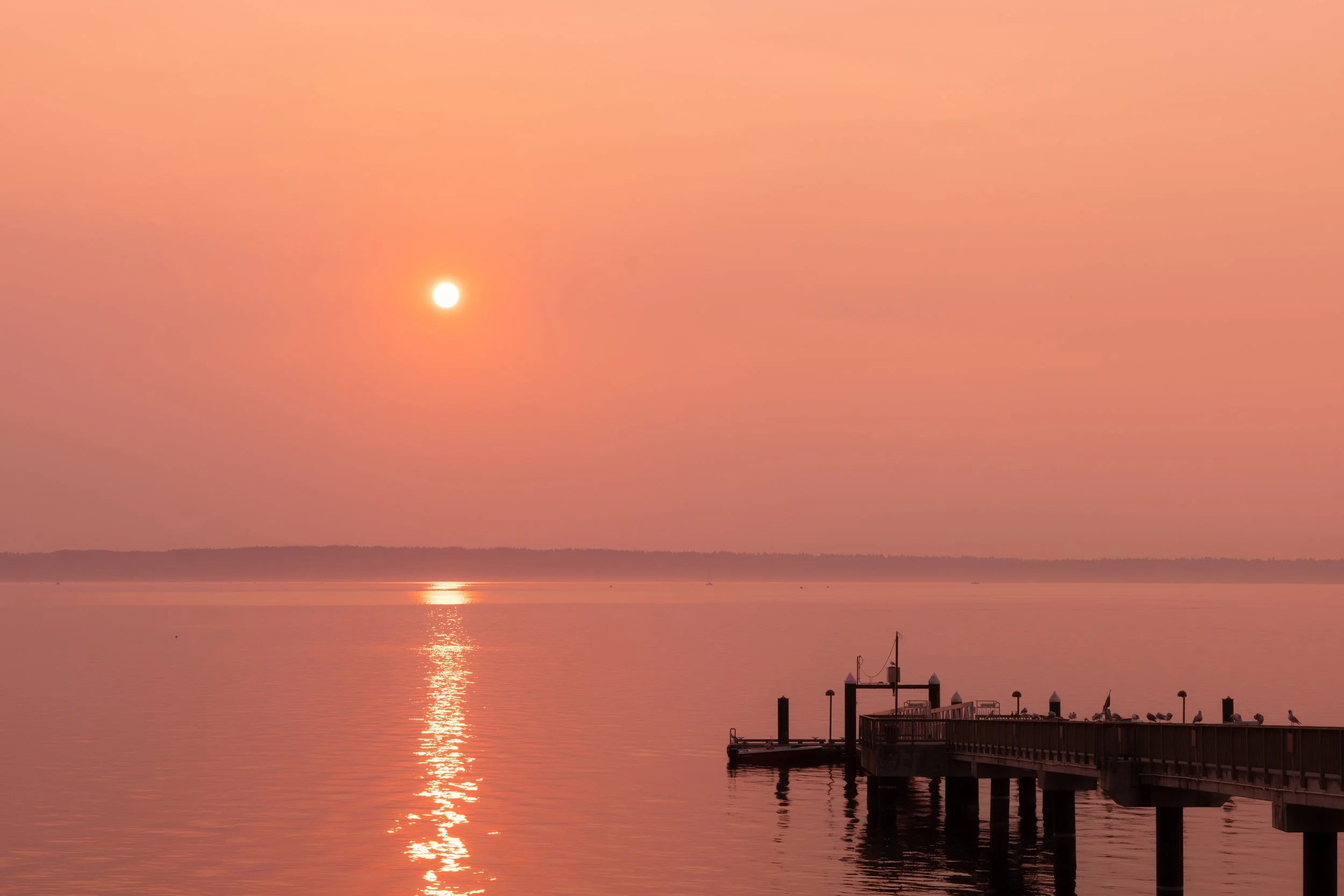 Hazy sunrise on the Puget Sound as seen from the Suquamish dock near Bainbridge Island
