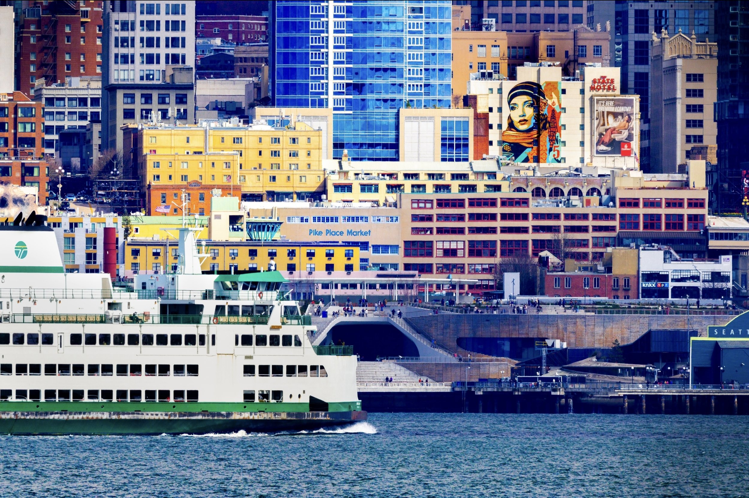 A view of the Bainbridge Island ferry in front of the Seattle waterfront with the city skyline in the background