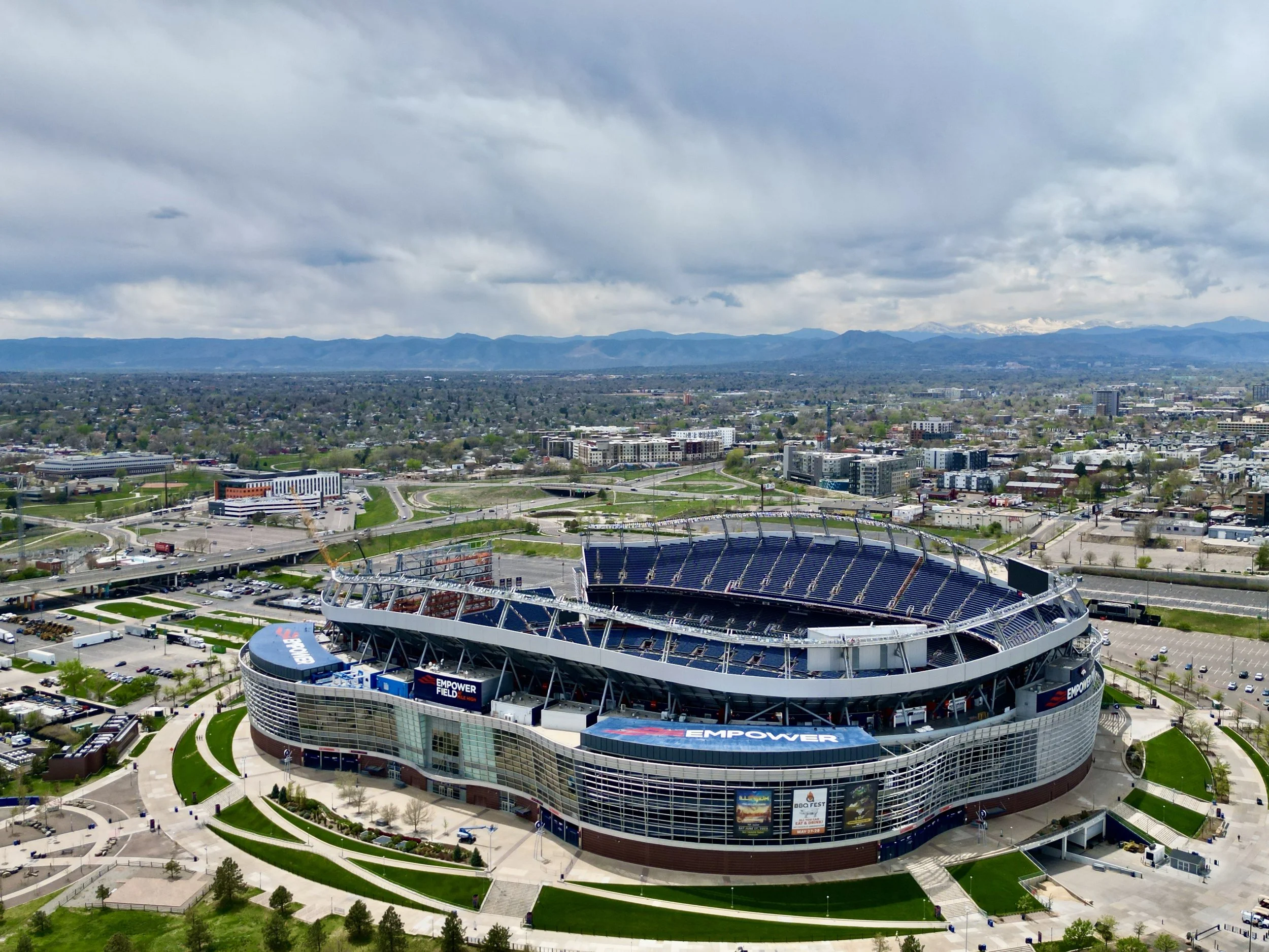 Aerial view of a football stadium and the surrounding city beneath cloudy skies.