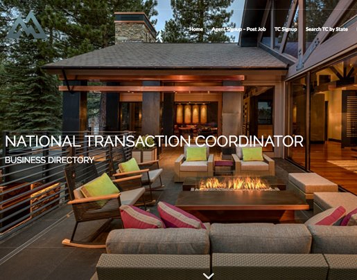 Luxury outdoor patio with seating area, fire pit, and large house with glass windows in the background.