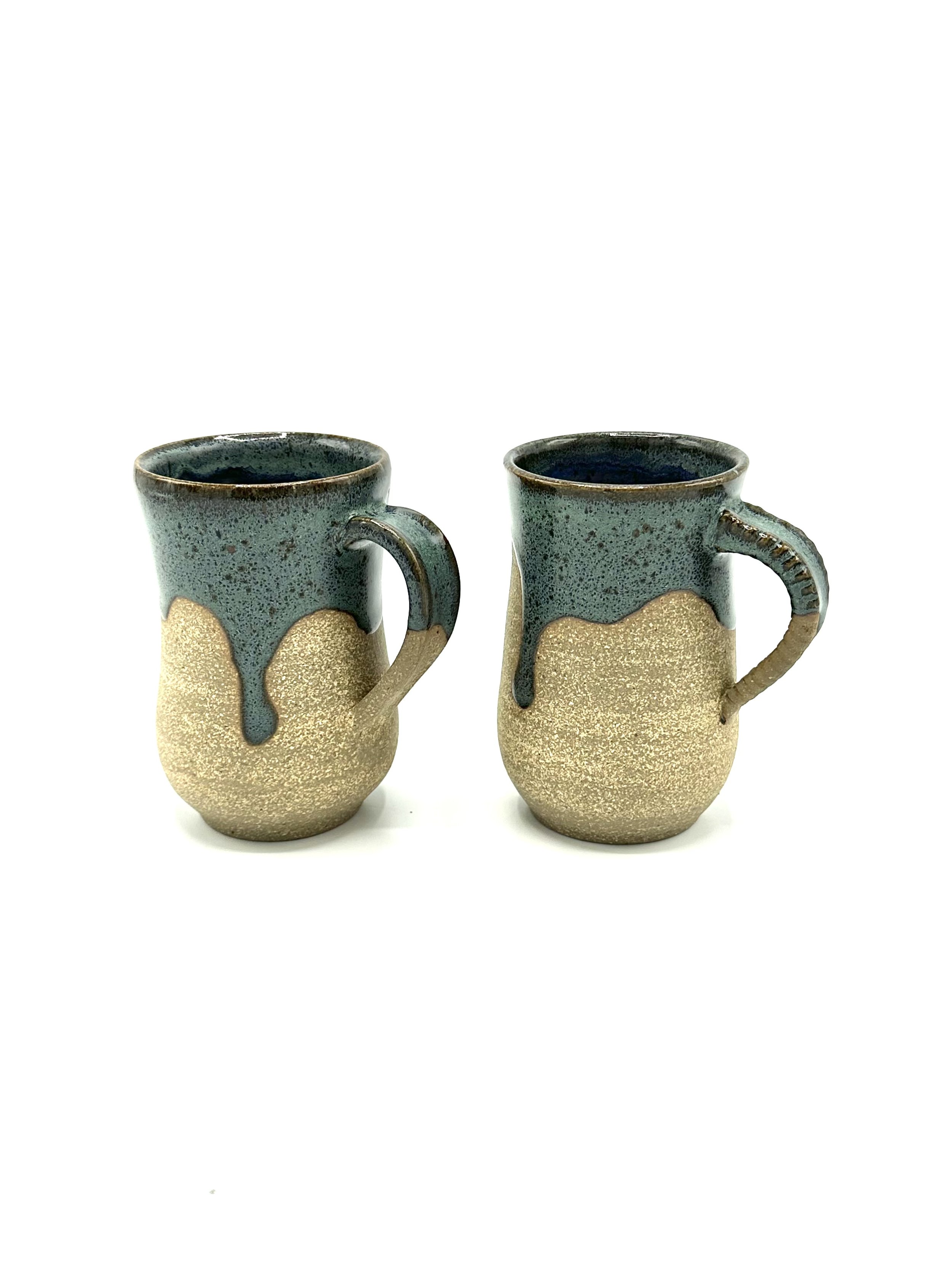 Two ceramic mugs with textured lower half, green glaze dripping from the top edge, and round yellow spots on the lower part, placed on a white background.