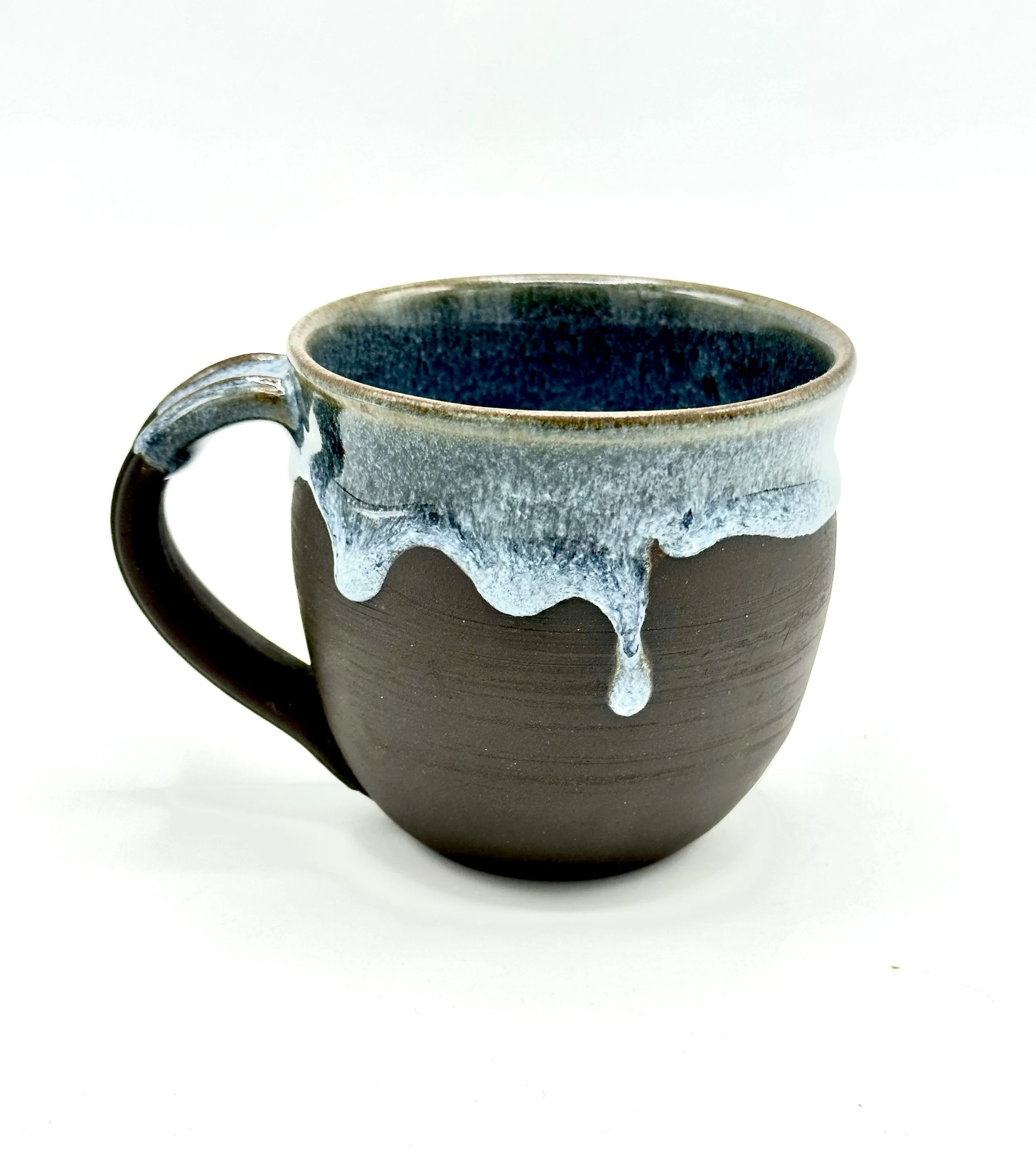 A ceramic mug with a dark brown base and a blue-green glazed upper portion, against a white background.