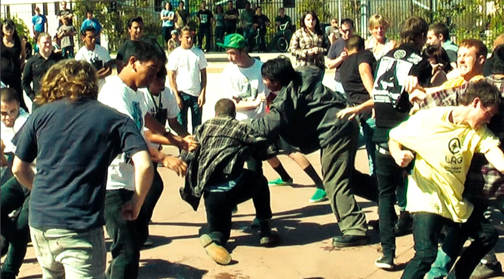 Crowd image: Breaking: Los Angeles documentary still of a crowd moshing in an outdoor public plaza during Agent Orange performance.