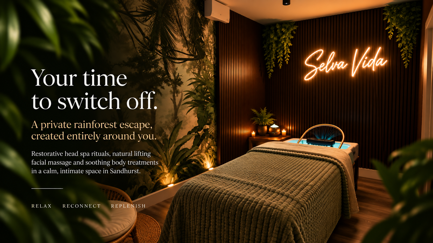 Selva Vida Rainforest Head Spa treatment room with tropical greenery, warm candlelight and dark wood feature wall.