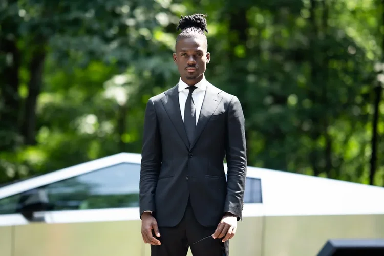 Prophet Jahhel Chosen standing outdoors in a dark suit
