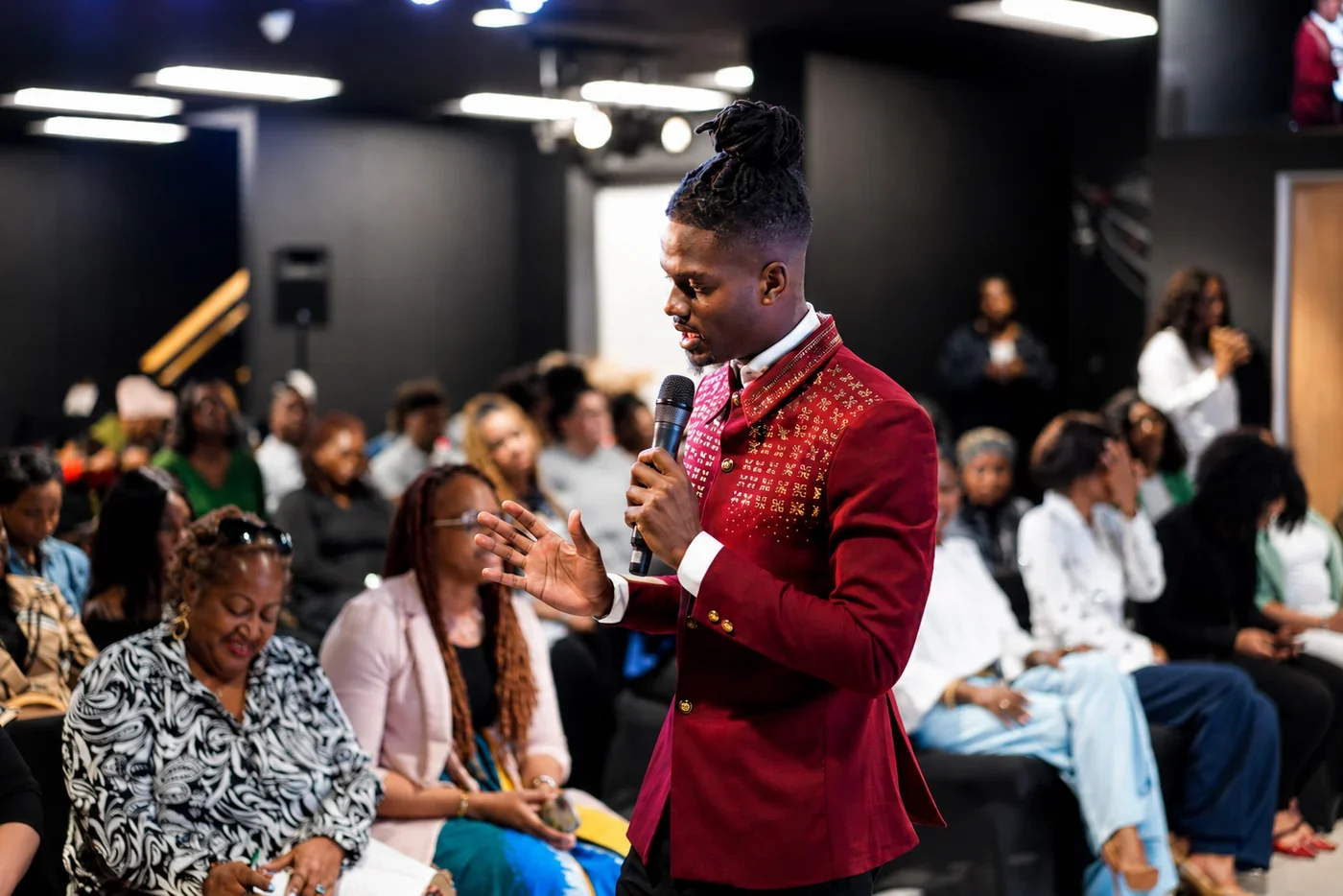 Prophet Jahhel Chosen teaching in a red jacket among a gathered community