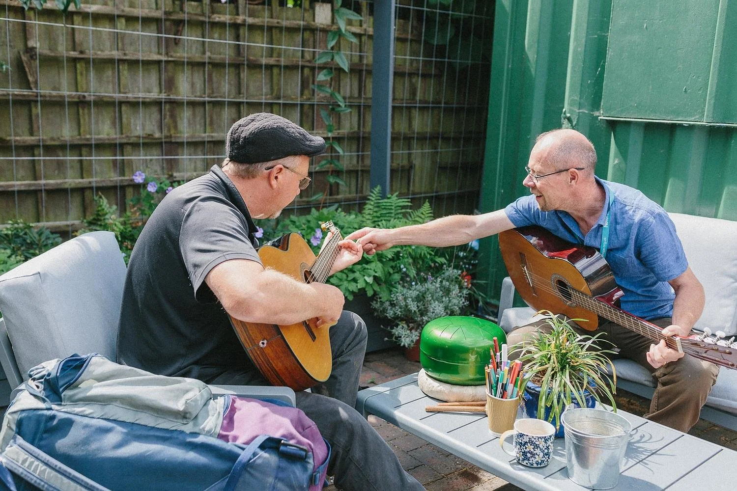Two men playing guitar together.