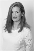 Black and white portrait of a young woman with shoulder-length hair, wearing a white shirt with the word 'BREAK' on the sleeve, smiling at the camera.