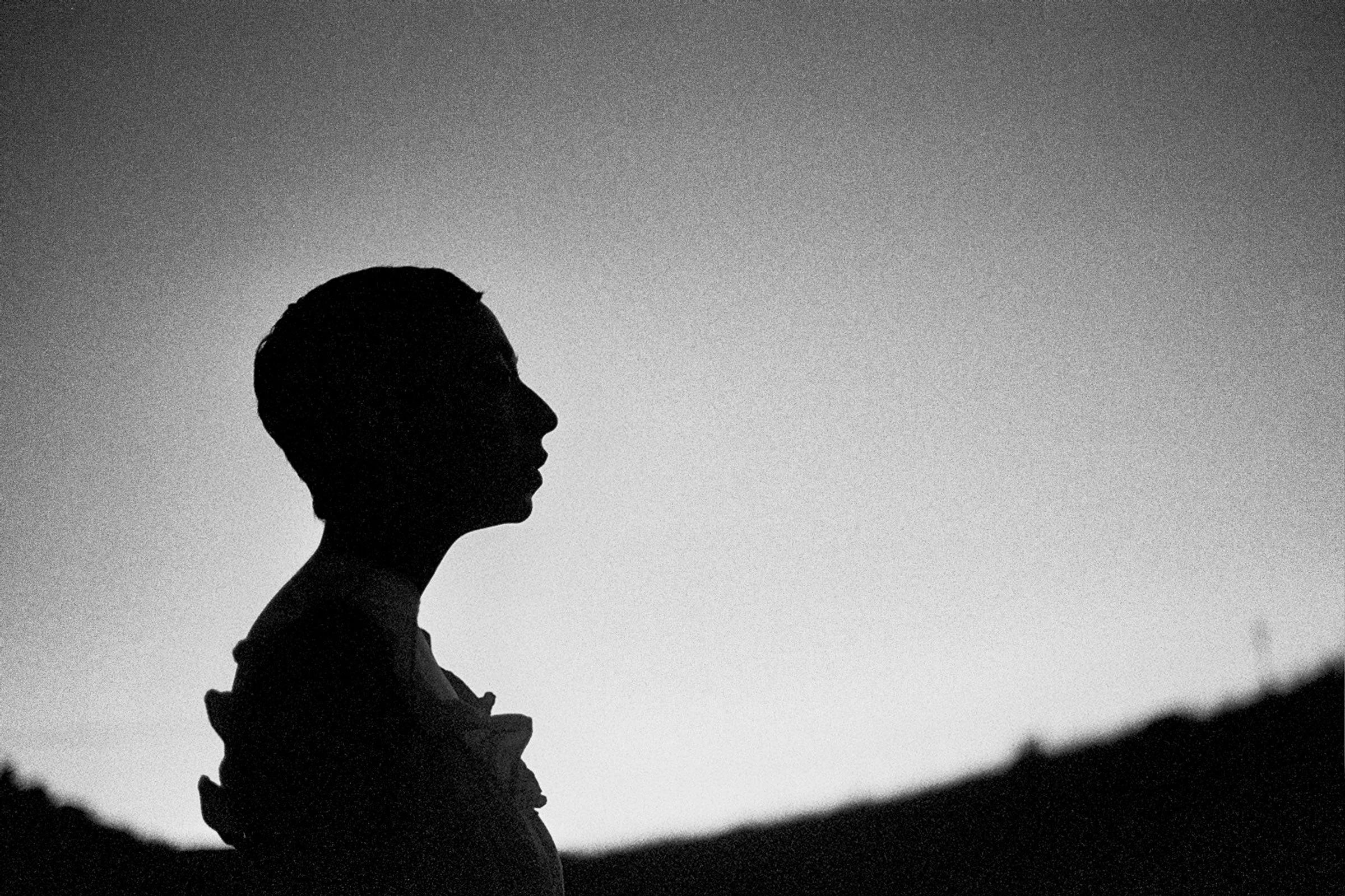 Silhouette of a person's profile against a grayscale background.