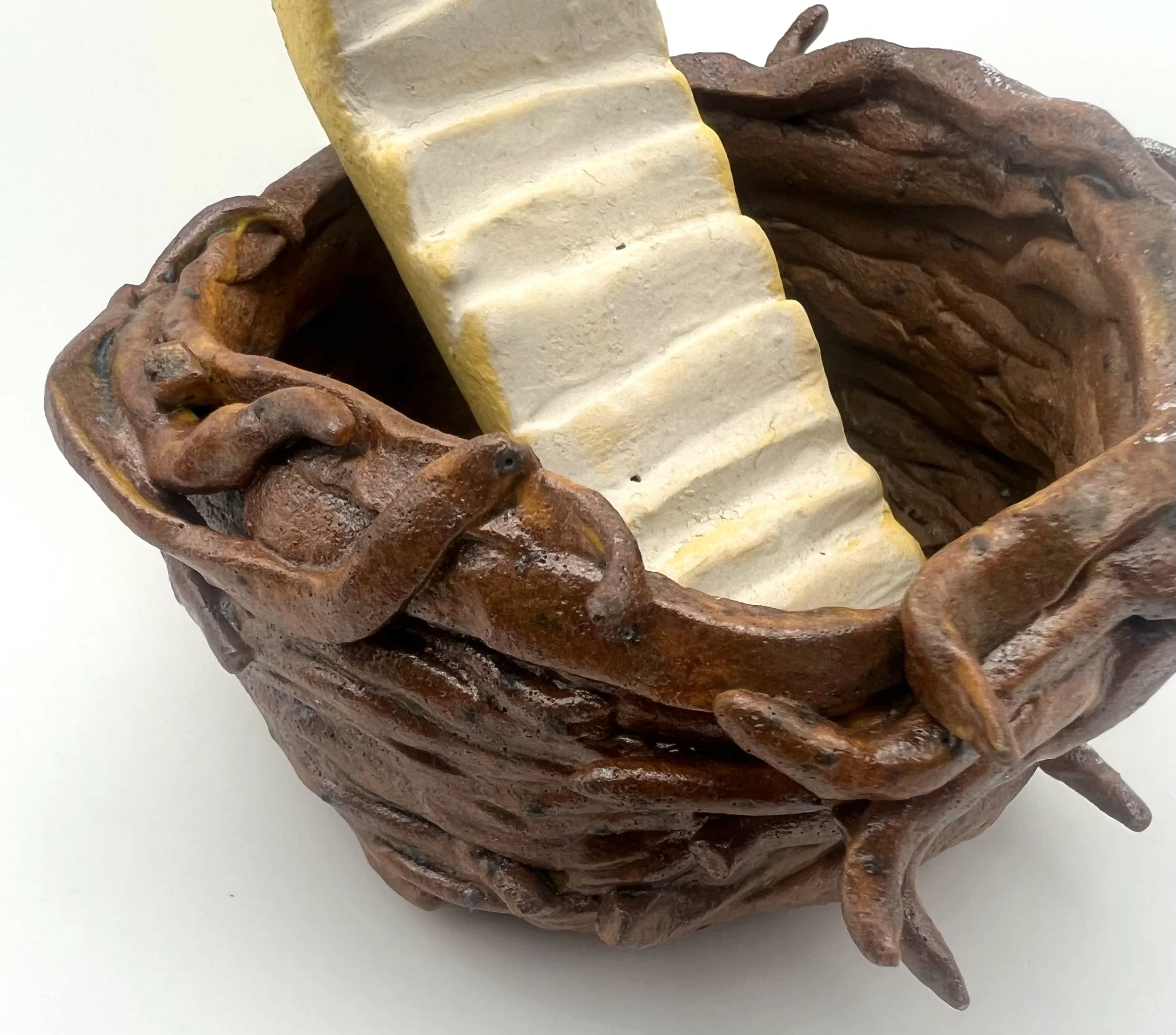 Close-up of a wooden sculpture with intricate carvings of a horse's face in a basket-like base, with a cream-colored staircase carved into the top.