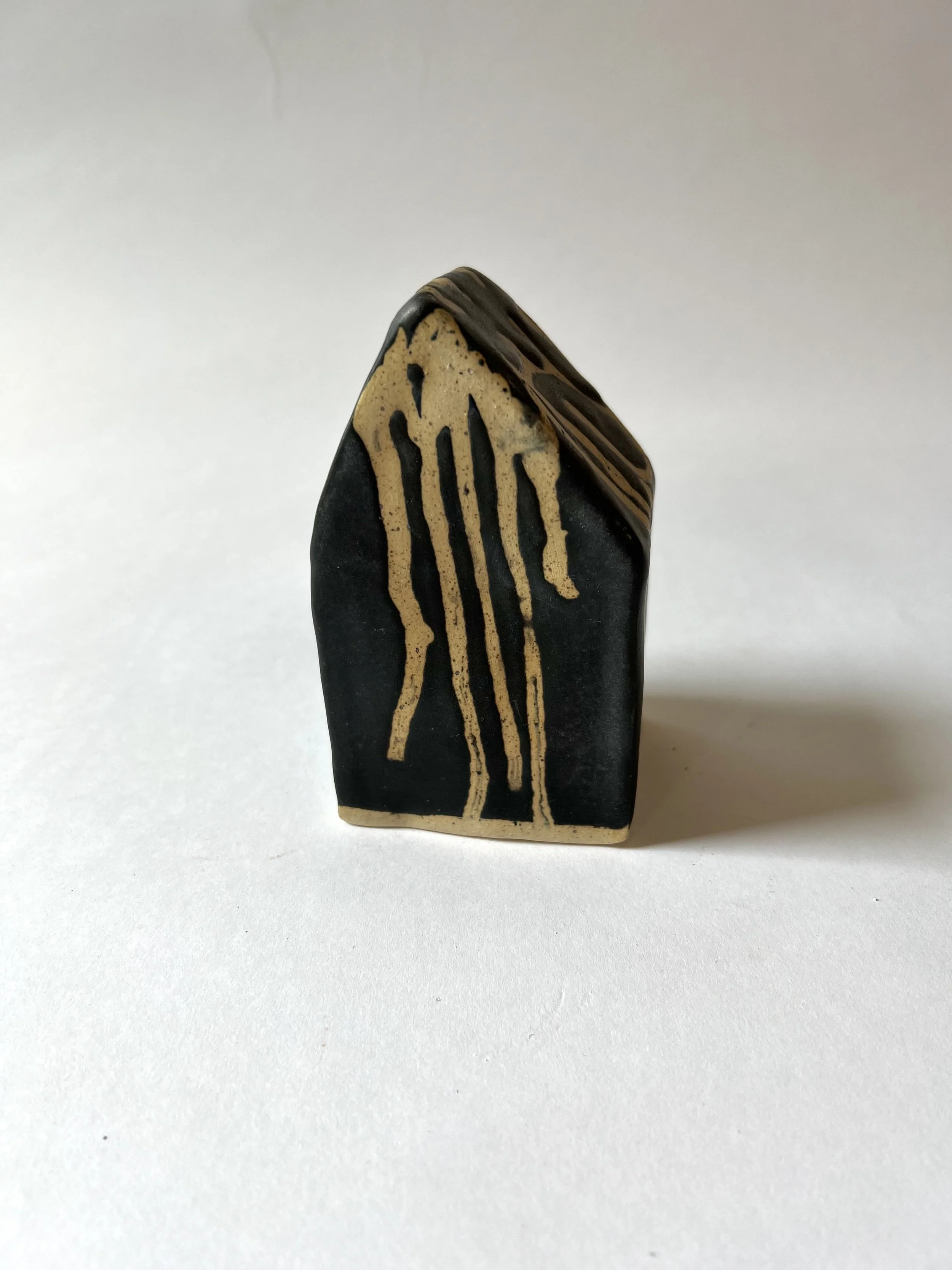 Close-up of a decorative object with black and beige colors, featuring a striped pattern and gold accents.