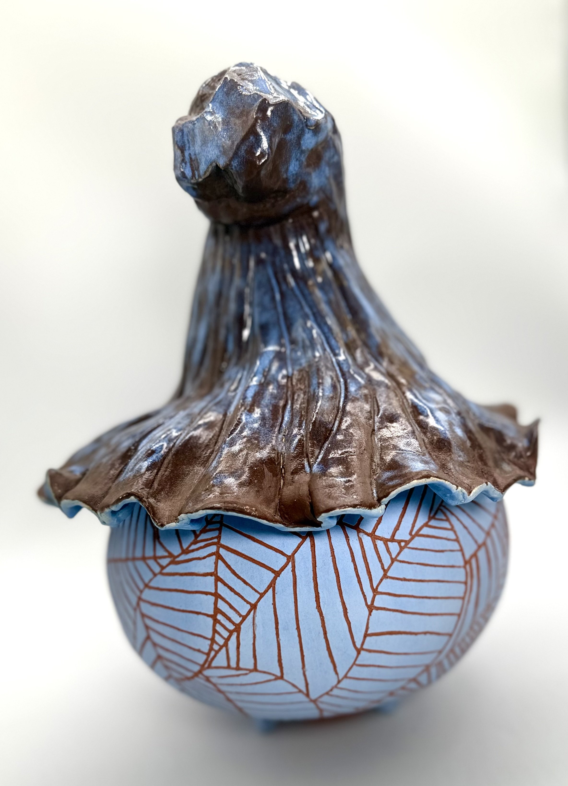 Close-up of a chocolate and blue foil-wrapped Hershey's Kiss on a white background.