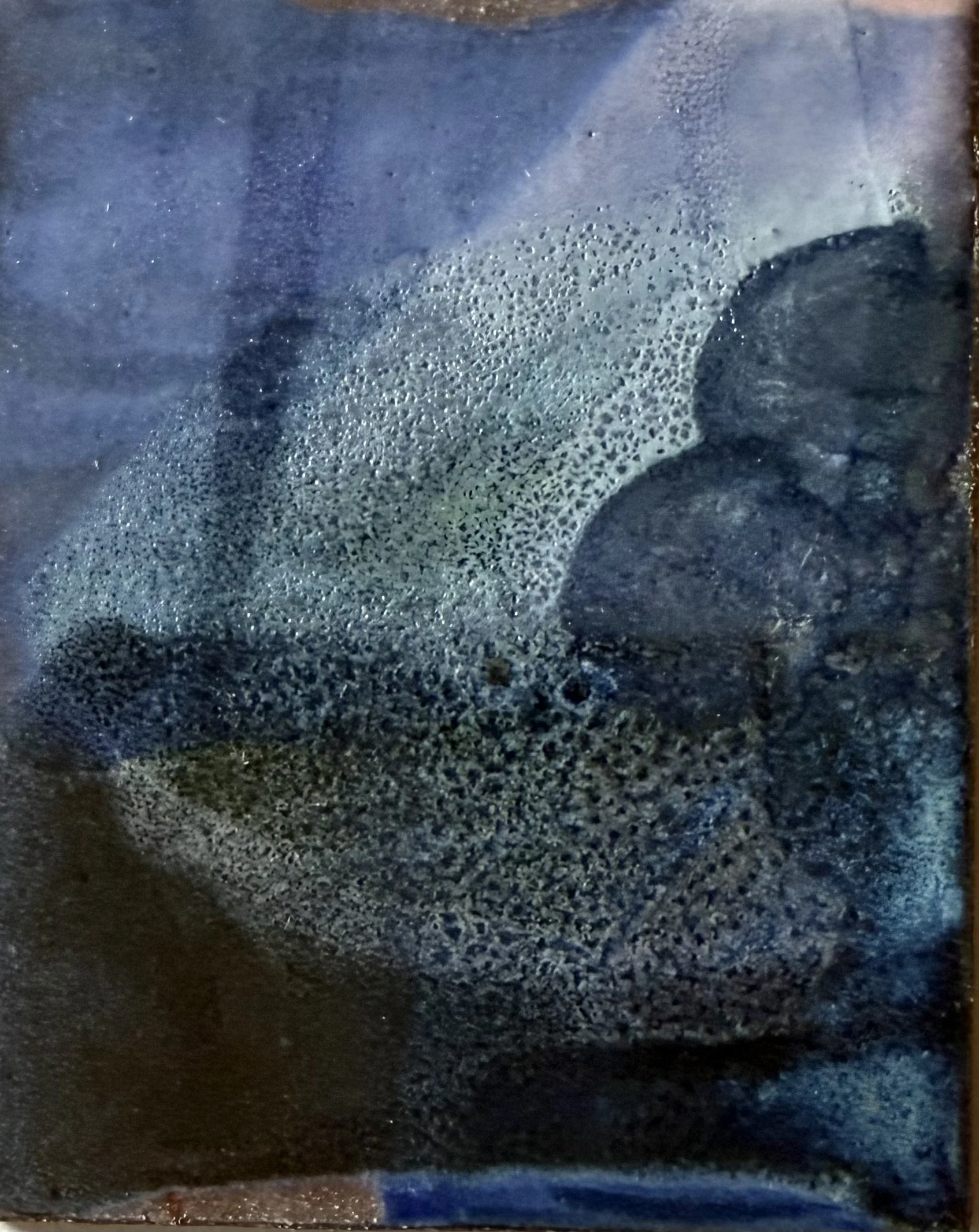 Close-up of a black surface with bubbles or foam forming a pattern on it.