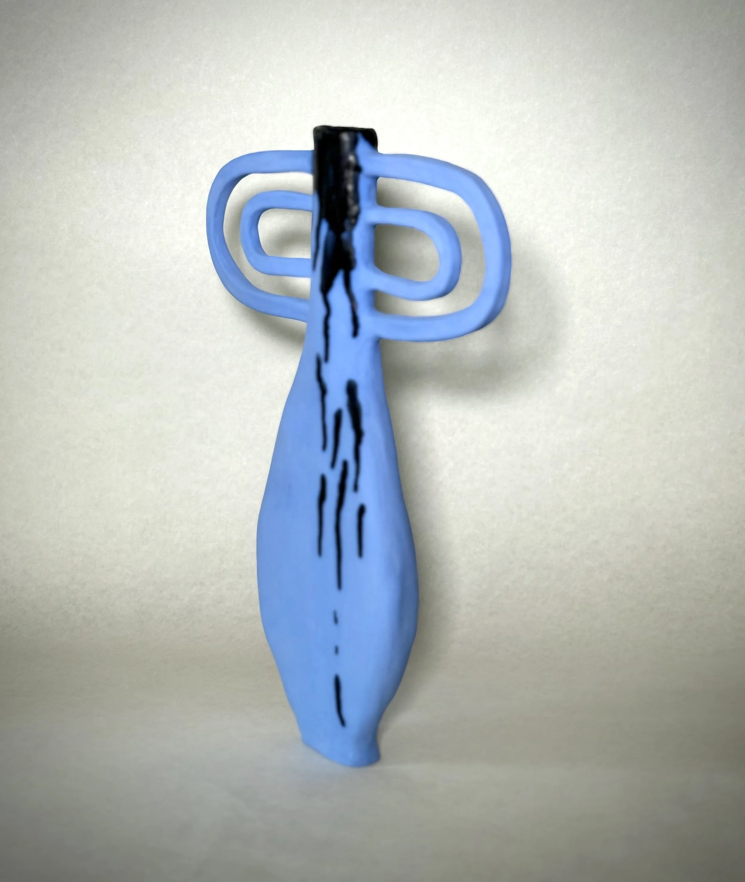 A blue plastic hair clip with a butterfly shape on a plain white surface.