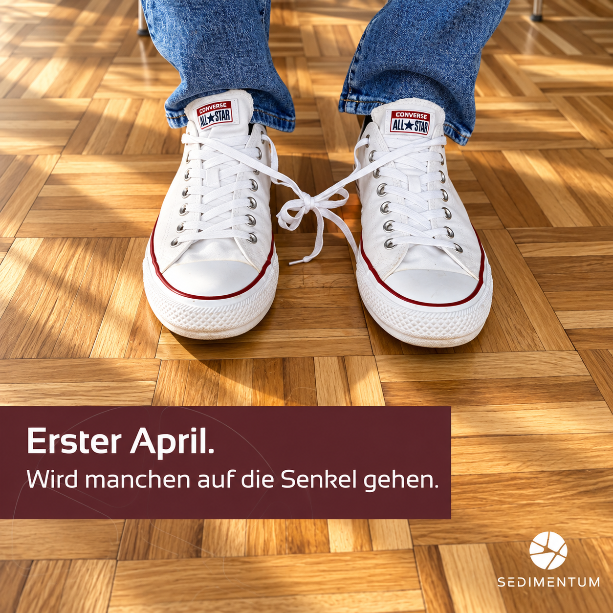 Weiße Converse auf Parkett mit Aprilscherz-Text.png