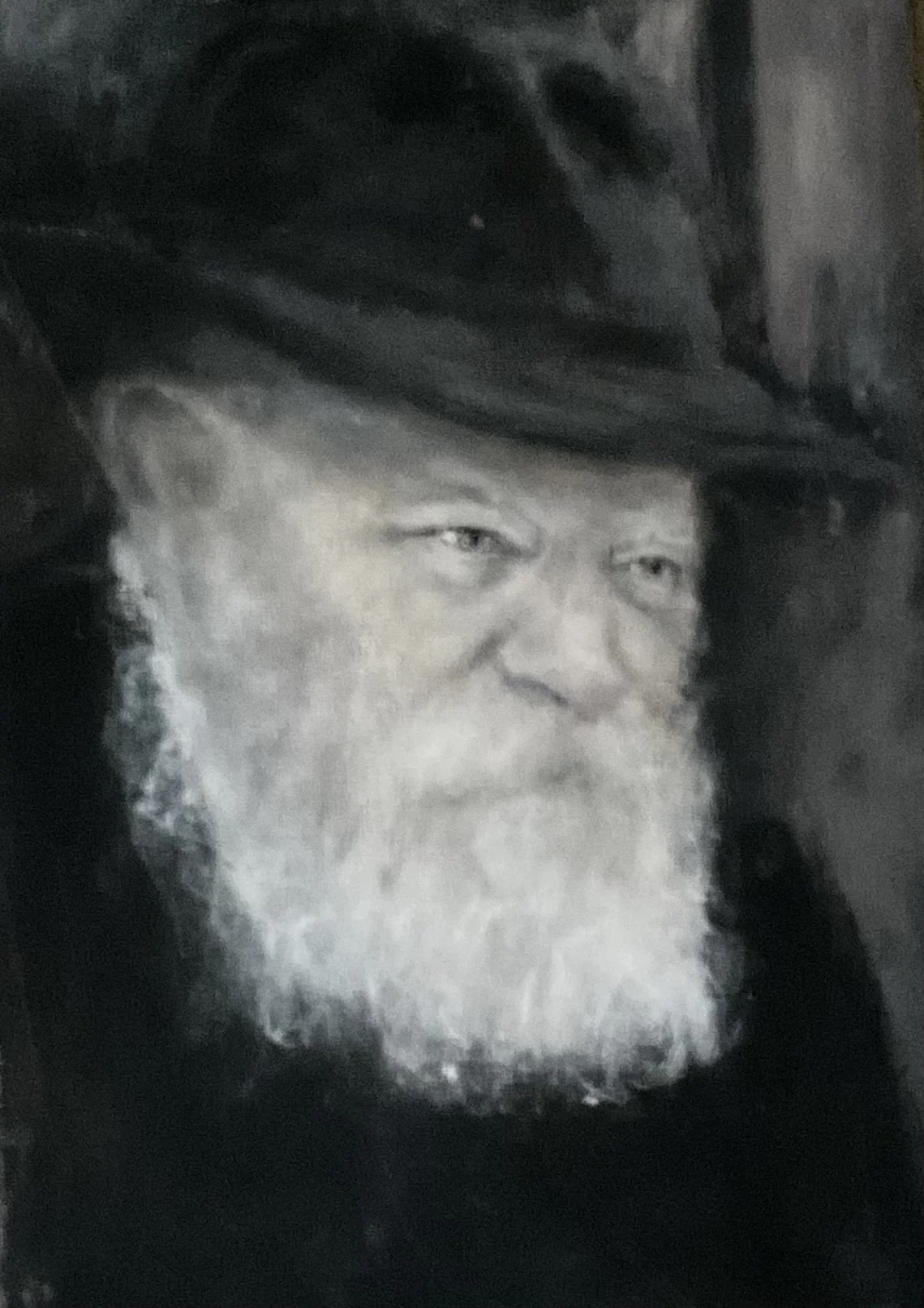 A black and white portrait of the loved Rebbi Scheerson with a long white beard, wearing a large black hat.