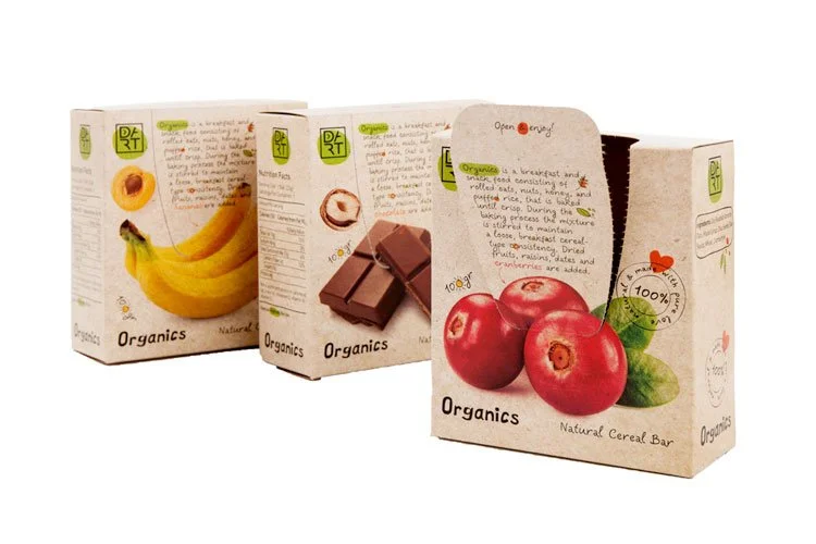 Three boxes of organic snacks with bananas, chocolate, and apples on the packaging.