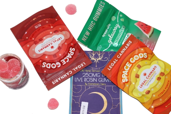 Assorted gummy candies in various colorful packaging, including cannabis-themed gummies and space-themed edible gummies.