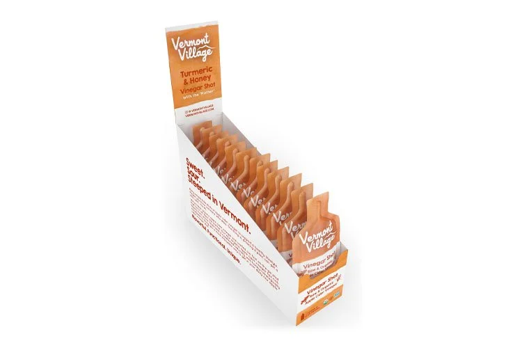 Vermont Village turmeric and honey vinegar shot in a display box.