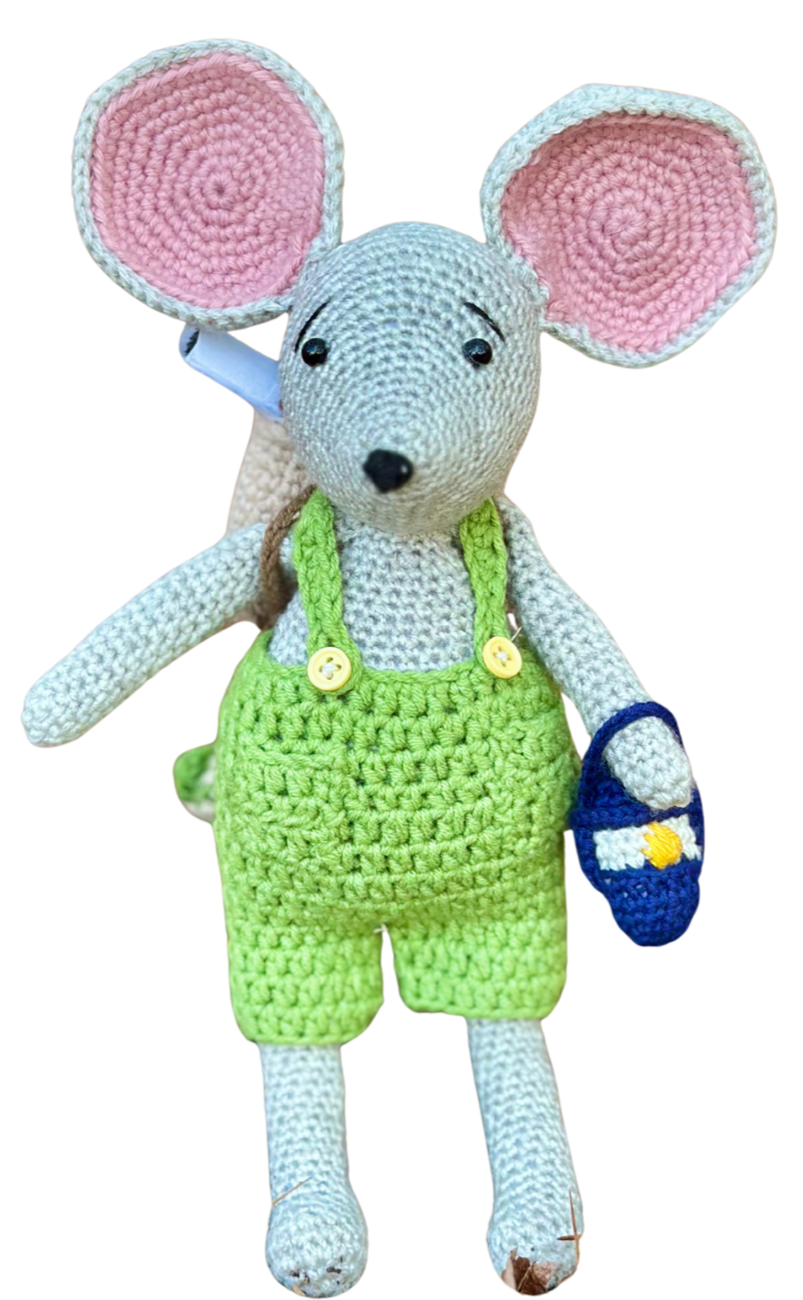 Max the Mouse, wearing green overalls, created by Stitches by Moonlight. He is the map maker of Moonlit Hollow. A storybook world that follows the crochet characters who live there.