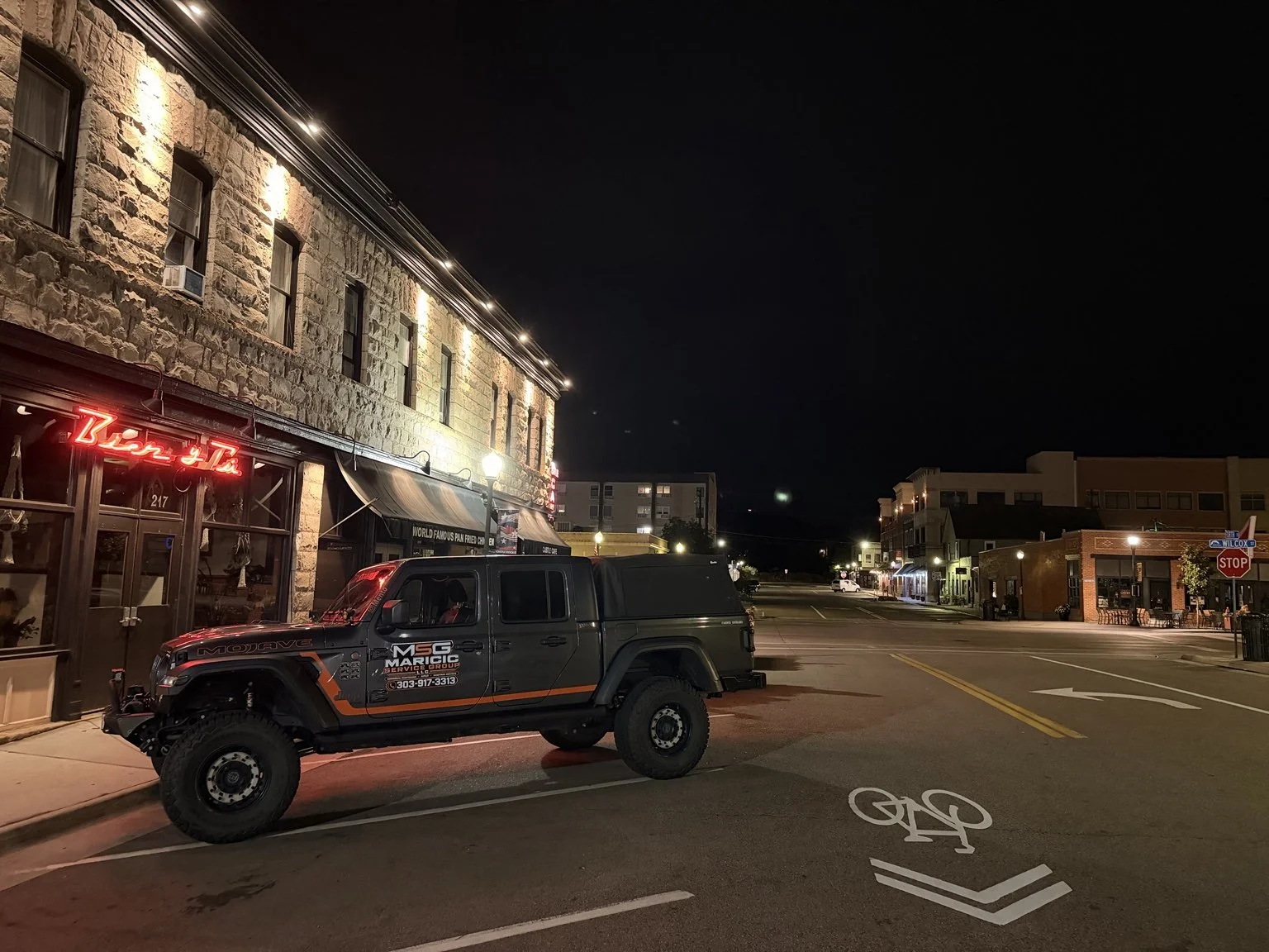 Maricic Services Group Jeep parked on a downtown Castle Rock street at night.