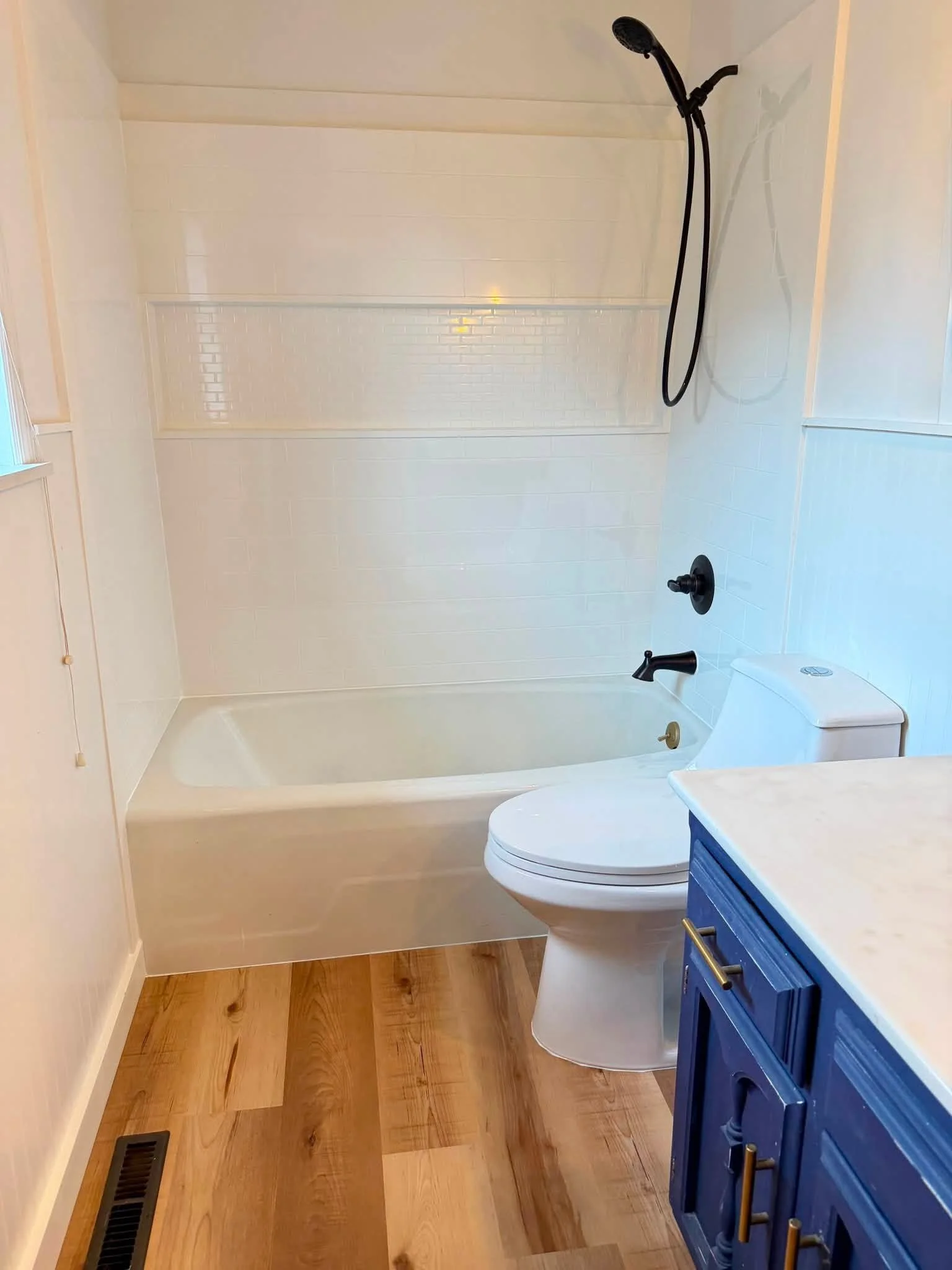 Newly renovated bathroom with new floors and tub surround system.