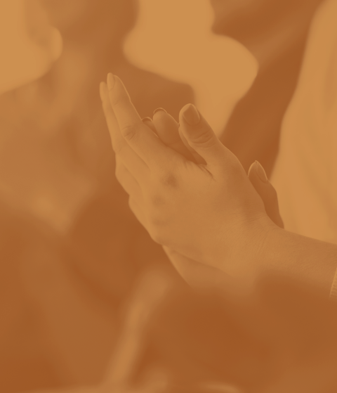 Close-up of a person with hands pressed together in a prayer or meditation pose