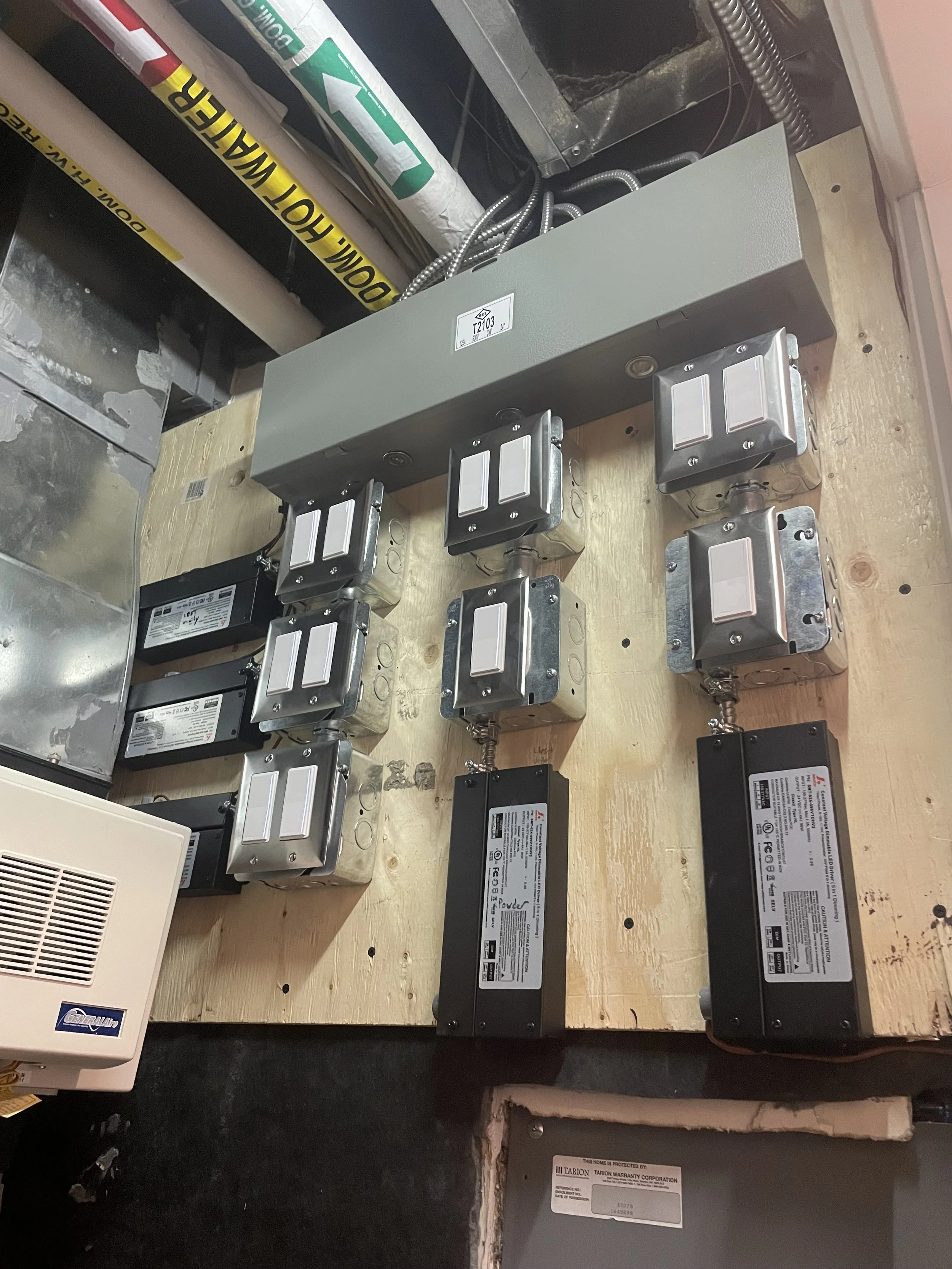 Electrical wiring, control boxes, and electrical panels installed on a wooden platform.