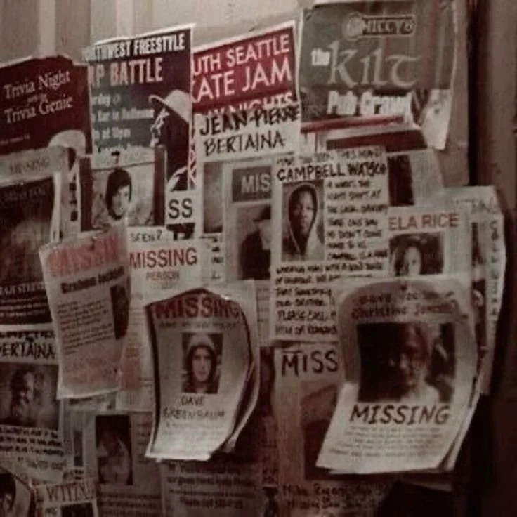 A collage of missing persons flyers and posters on a wall, including photos and descriptions, with various headlines and messages.