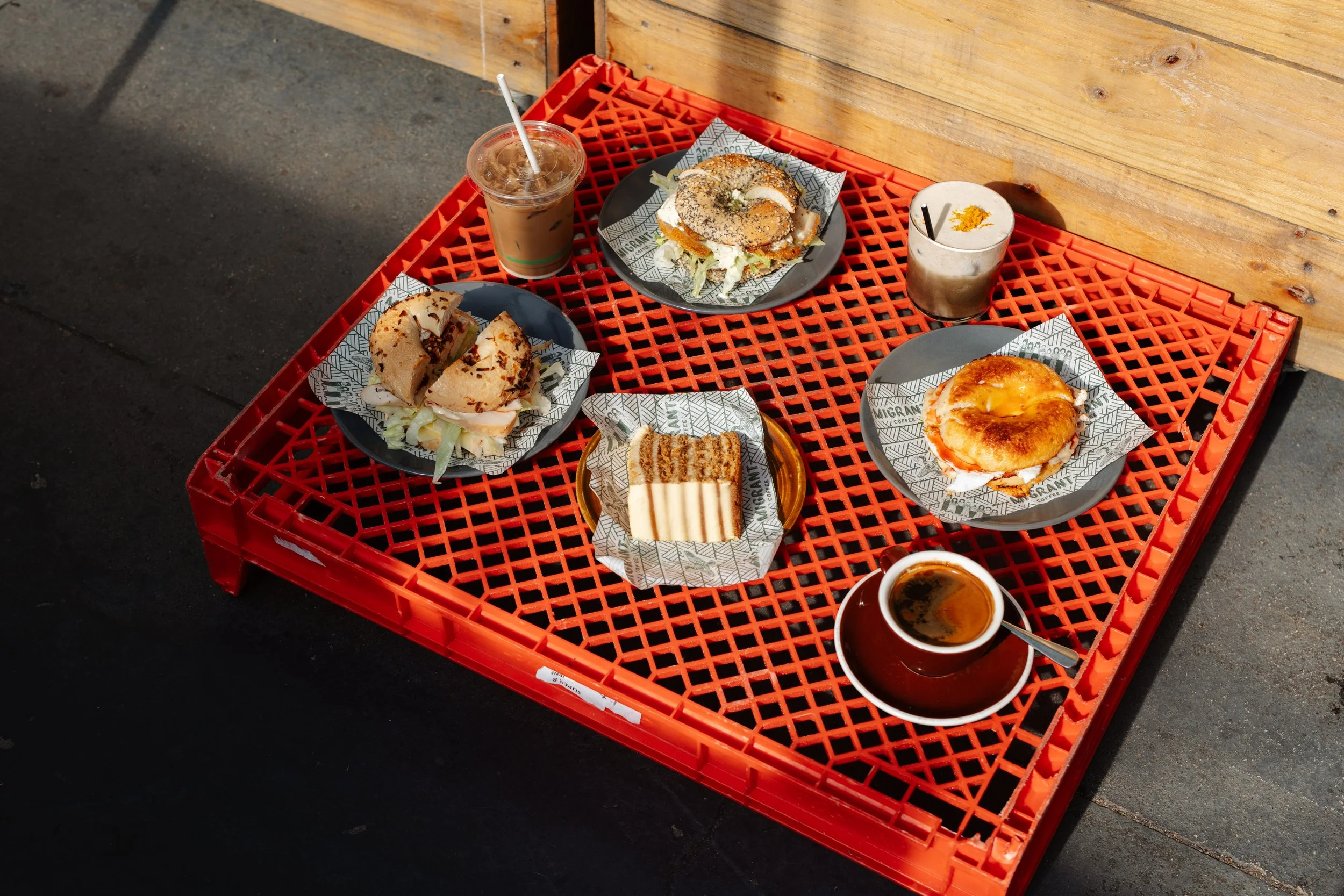 Breakfast spread at Migrant Coffee in West Foostcray, featuring different bagel flavours, paired with coffee and house-made carrot cake