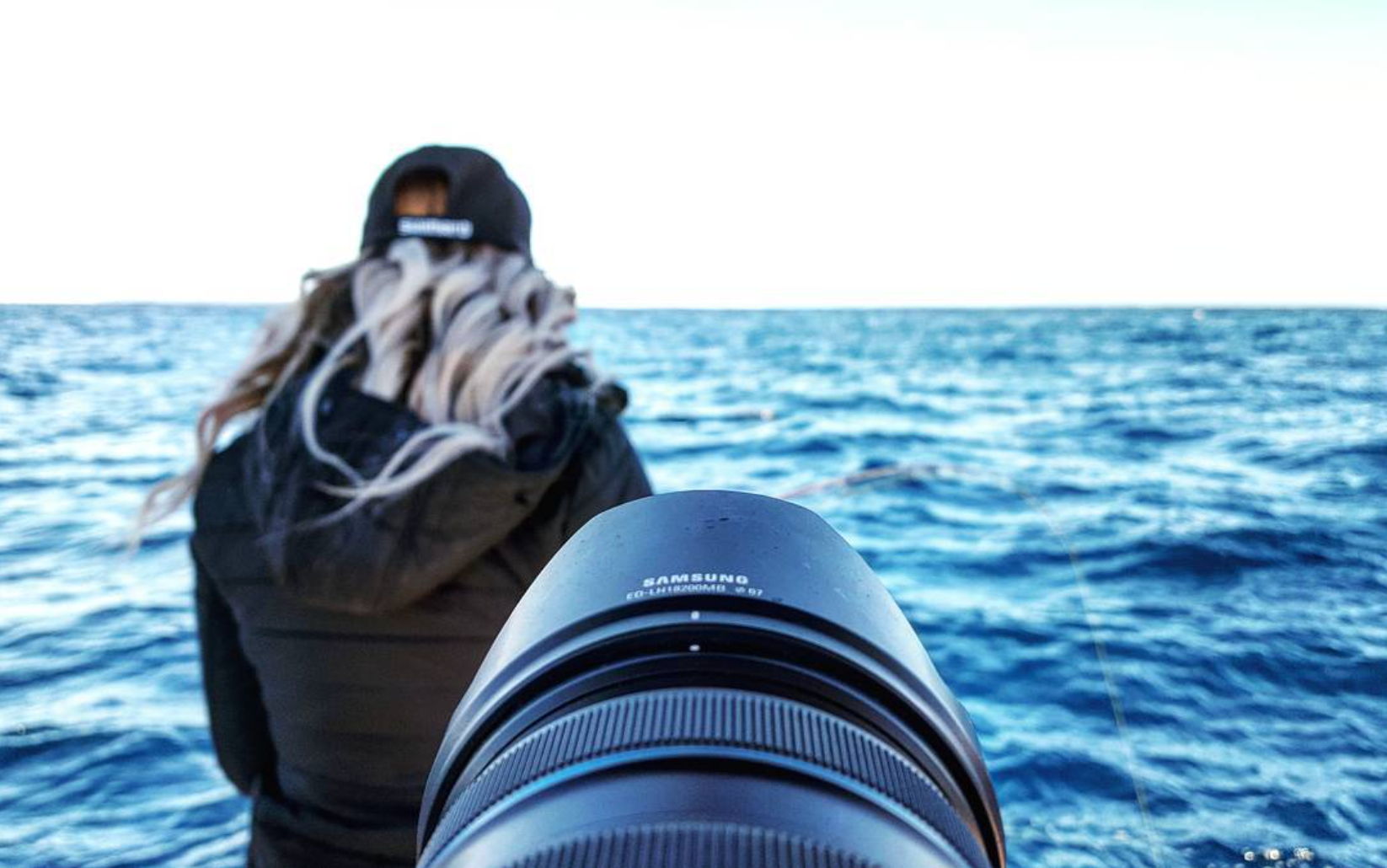 Camera lens in the foreground while filming an angler offshore during the Stradic CI4+ shoot.