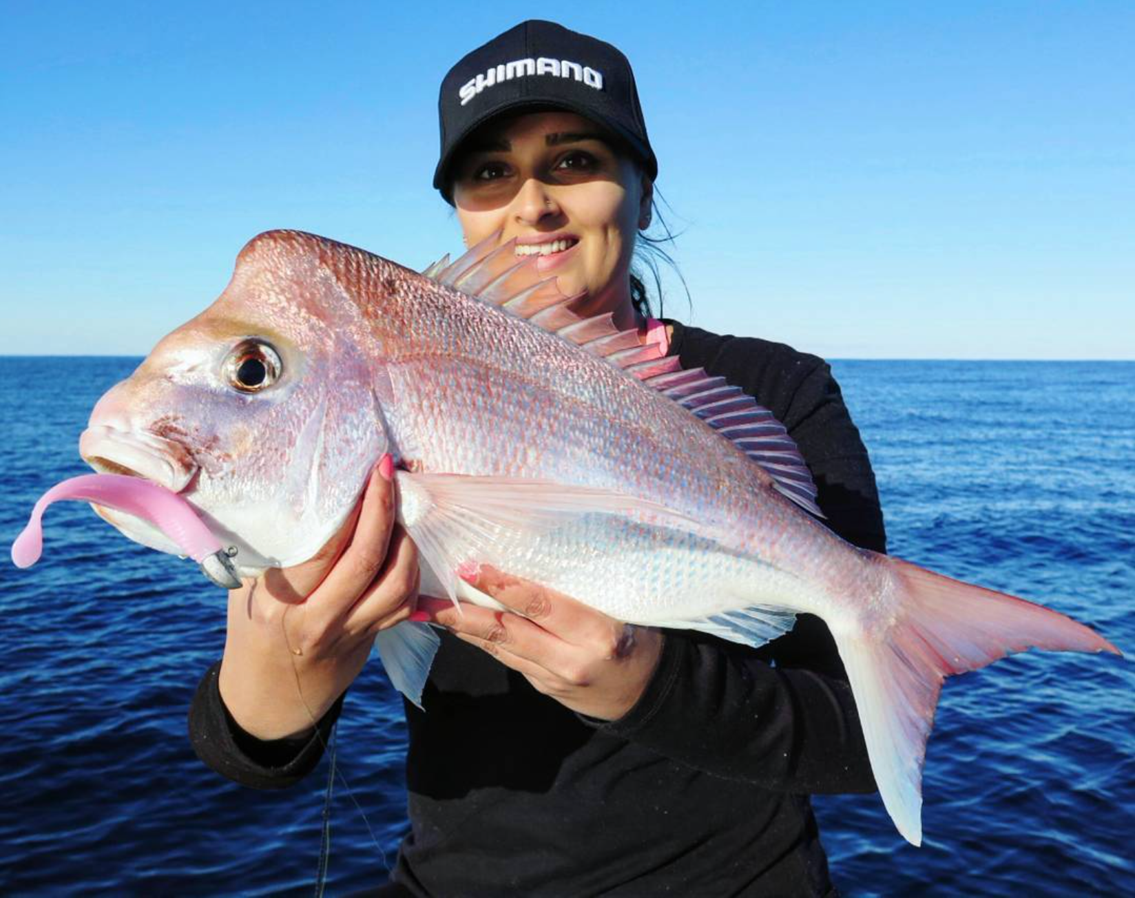 An angler holding a large fish on the boat during the Stradic CI4+ shoot.