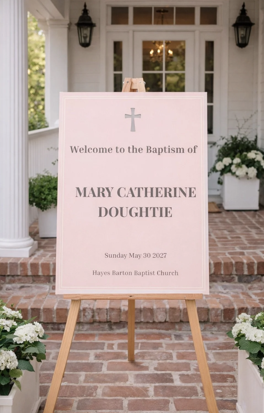 A pink sign welcoming guests to the baptism of Mary Catherine Doughtie on Sunday, May 30, 2027, at Hayes Barton Baptist Church, with a cross symbol at the top, situated in front of the church entrance with white flowers in planters nearby.