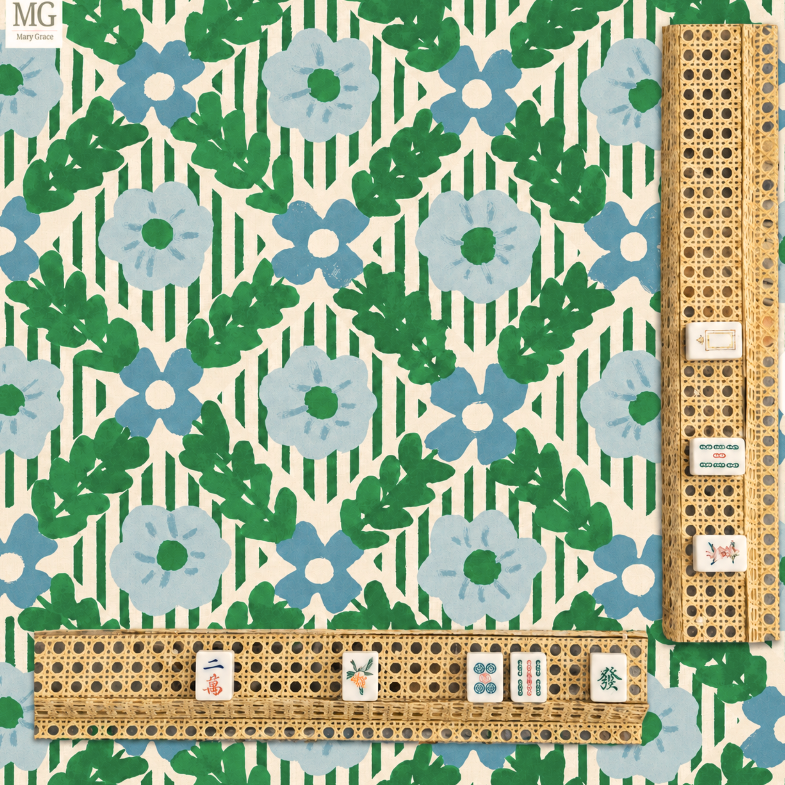Close-up view of a mahjong game set with tiles arranged on a decorative green, blue, and white floral-patterned tablecloth. Some tiles show Chinese characters and symbols.
