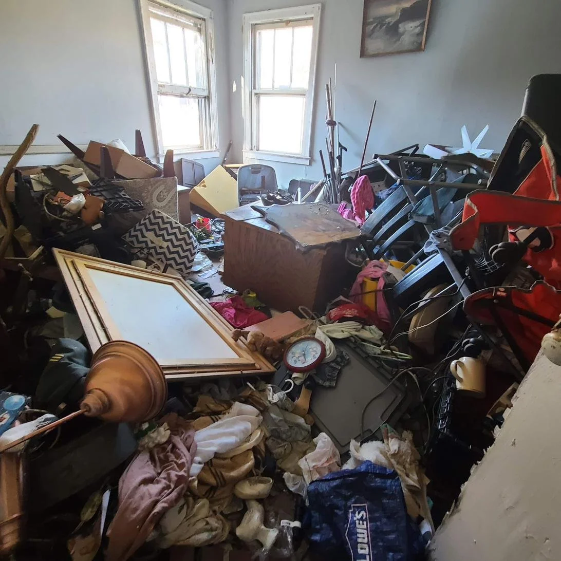 Cluttered room packed with furniture and boxes before a residential junk removal cleanout in Memphis, TN.