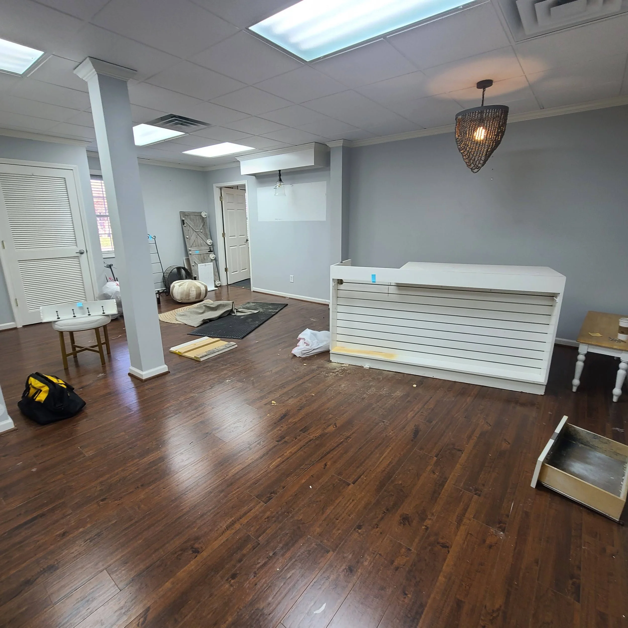 Room mid-renovation with hardwood floors and construction materials during a demolition cleanup in Memphis, TN.