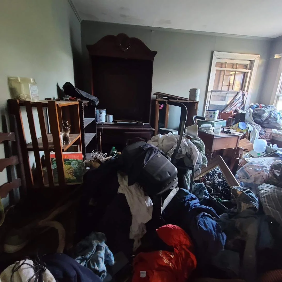 Messy living room with furniture, bags, and clutter before a full residential junk removal in Memphis, TN.