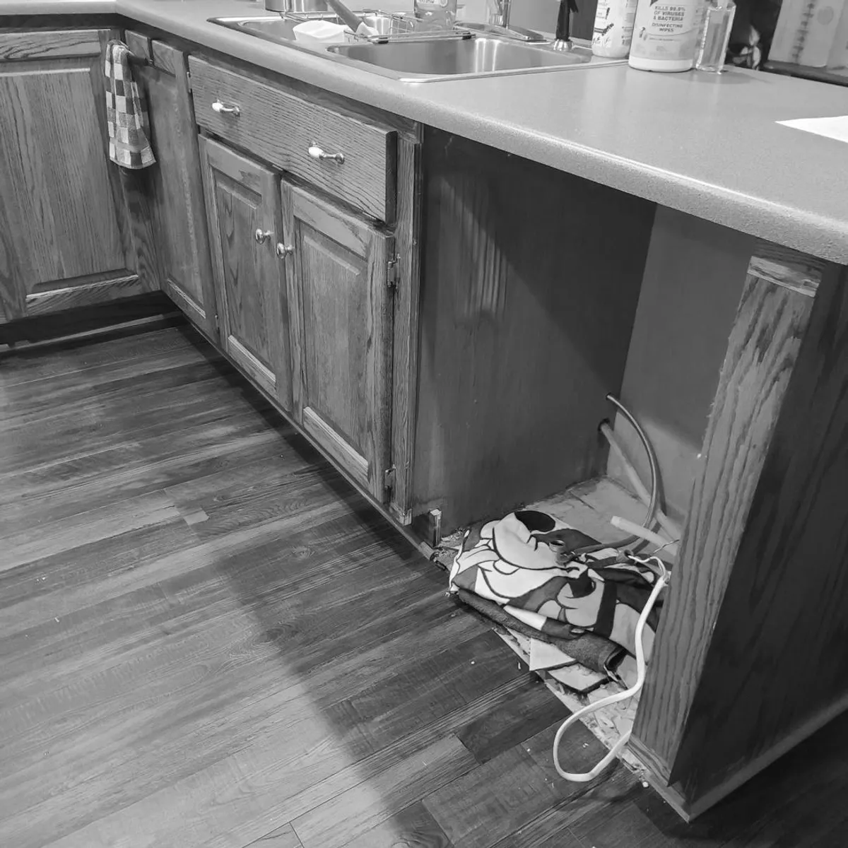 Kitchen cabinet missing a panel, exposing wiring, before an appliance removal service in Memphis, TN.