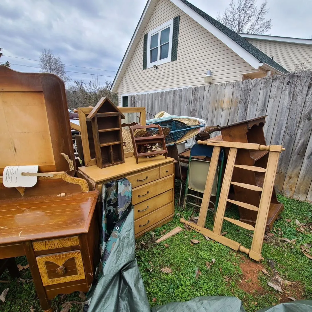 Pile of discarded wooden furniture outside a home before a residential junk removal pickup in Memphis, TN.