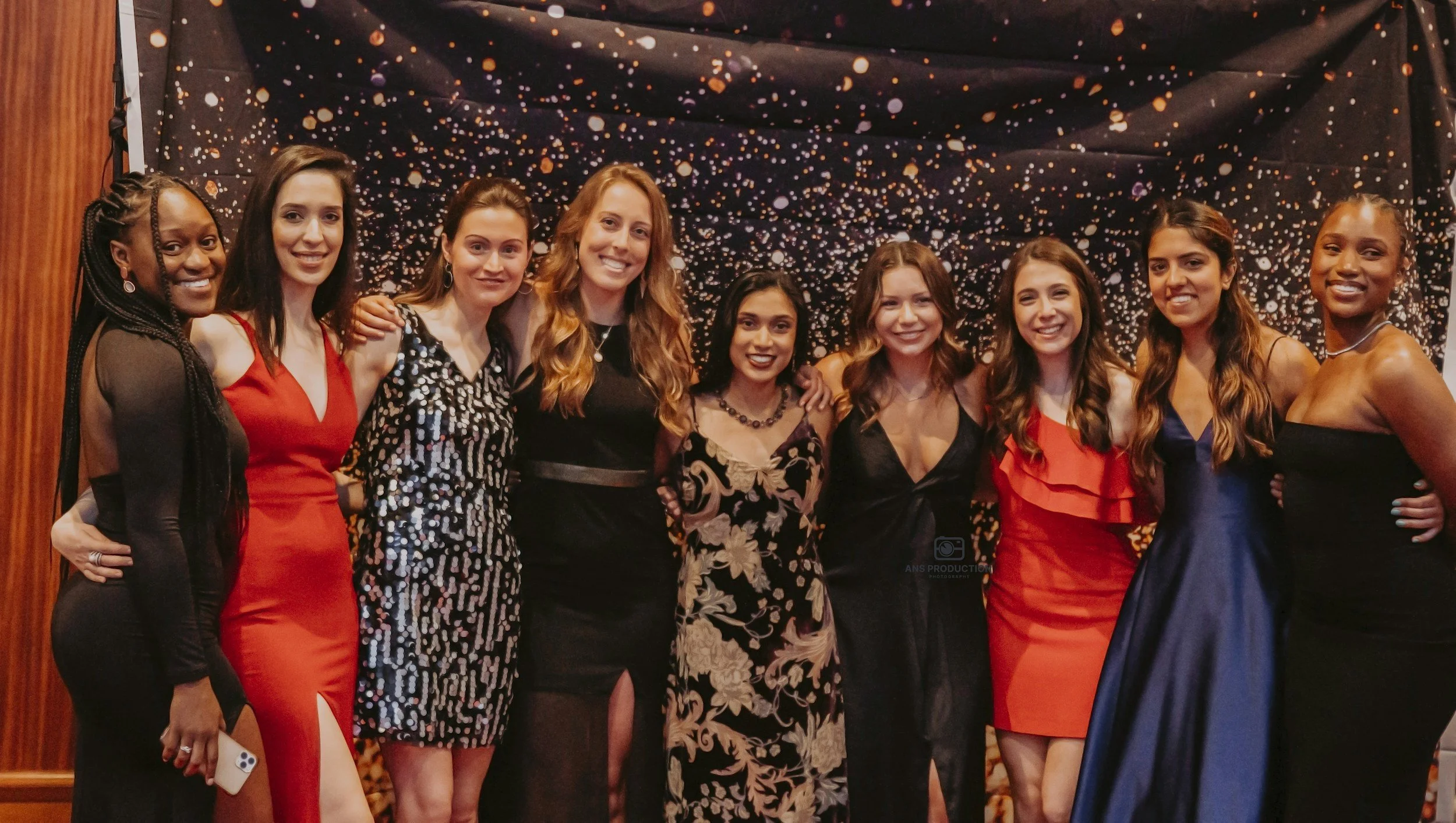 Sorority members dressed for a formal event and celebrating together.