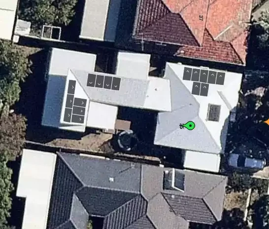 Aerial view of rooftops and yard of residential homes in a neighborhood.